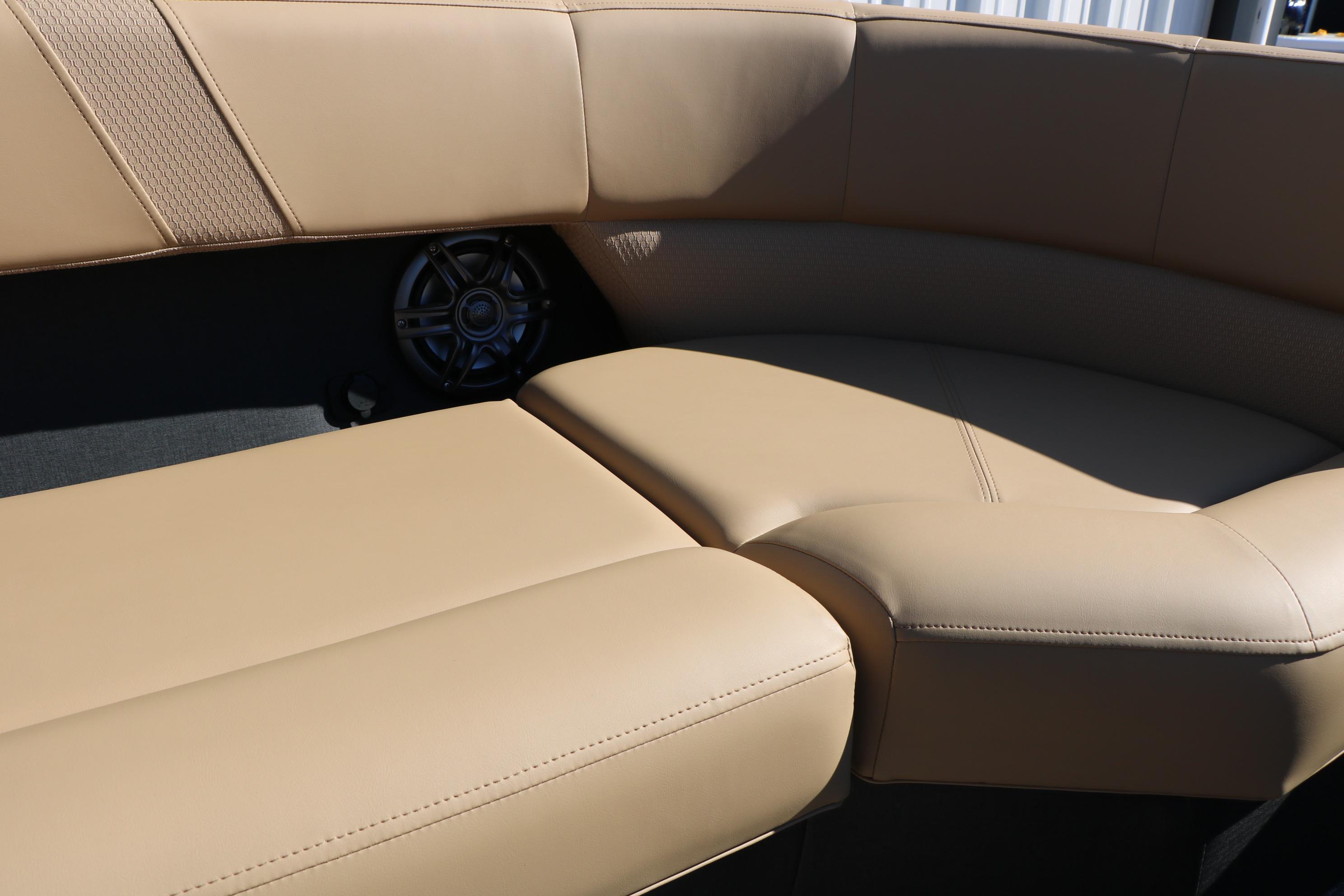 Luxurious beige seating on 2026 Evotti 525 QL Tri-Toon boat, featuring integrated speaker.
