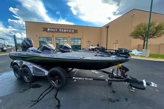 2026 Ranger Z518 Cup-Equipped boat on trailer outside service center, under cloudy sky.