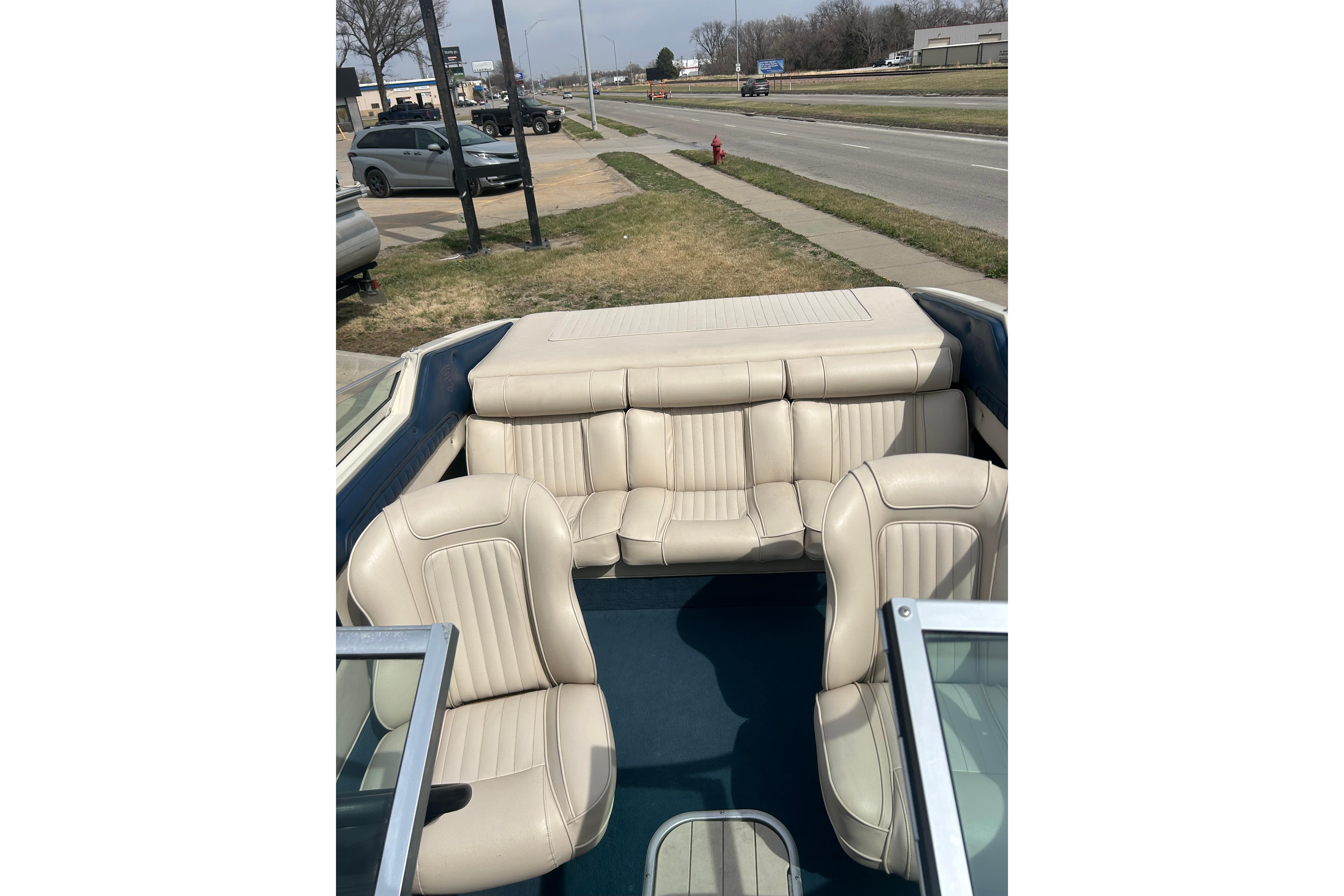 Interior of a 1996 Mariah 180 Shabah boat with beige seating and blue flooring.
