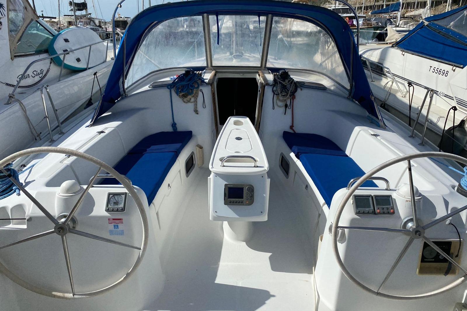 2007 Beneteau Cyclades 43.3 sailboat cockpit with dual steering wheels and blue seating.