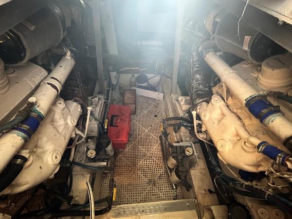 Engine room of 1985 Hatteras 45 Convertible yacht, showcasing dual engines and mechanical components.