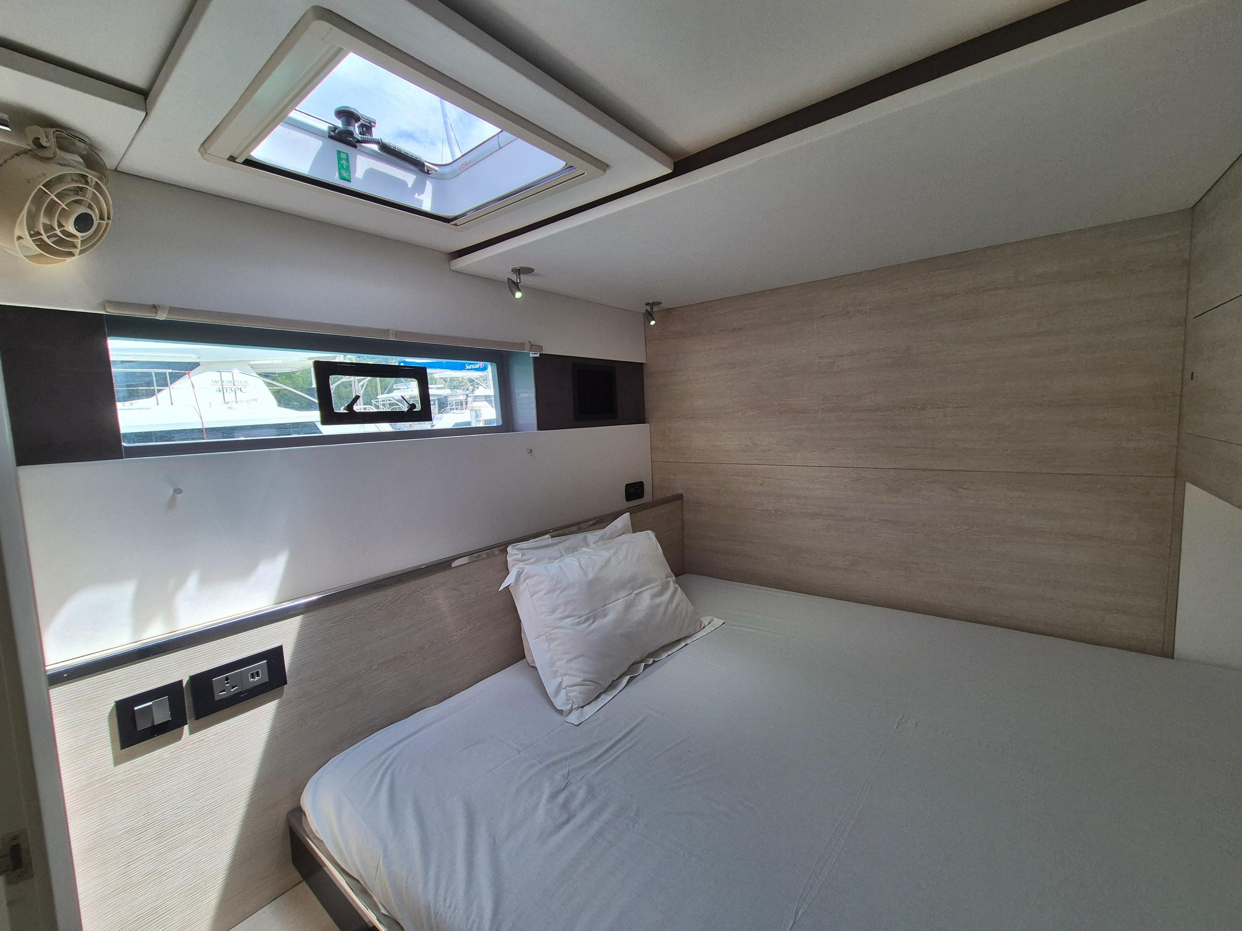 Modern bedroom interior in a 2020 Leopard 50 yacht, featuring a skylight and minimalist design.