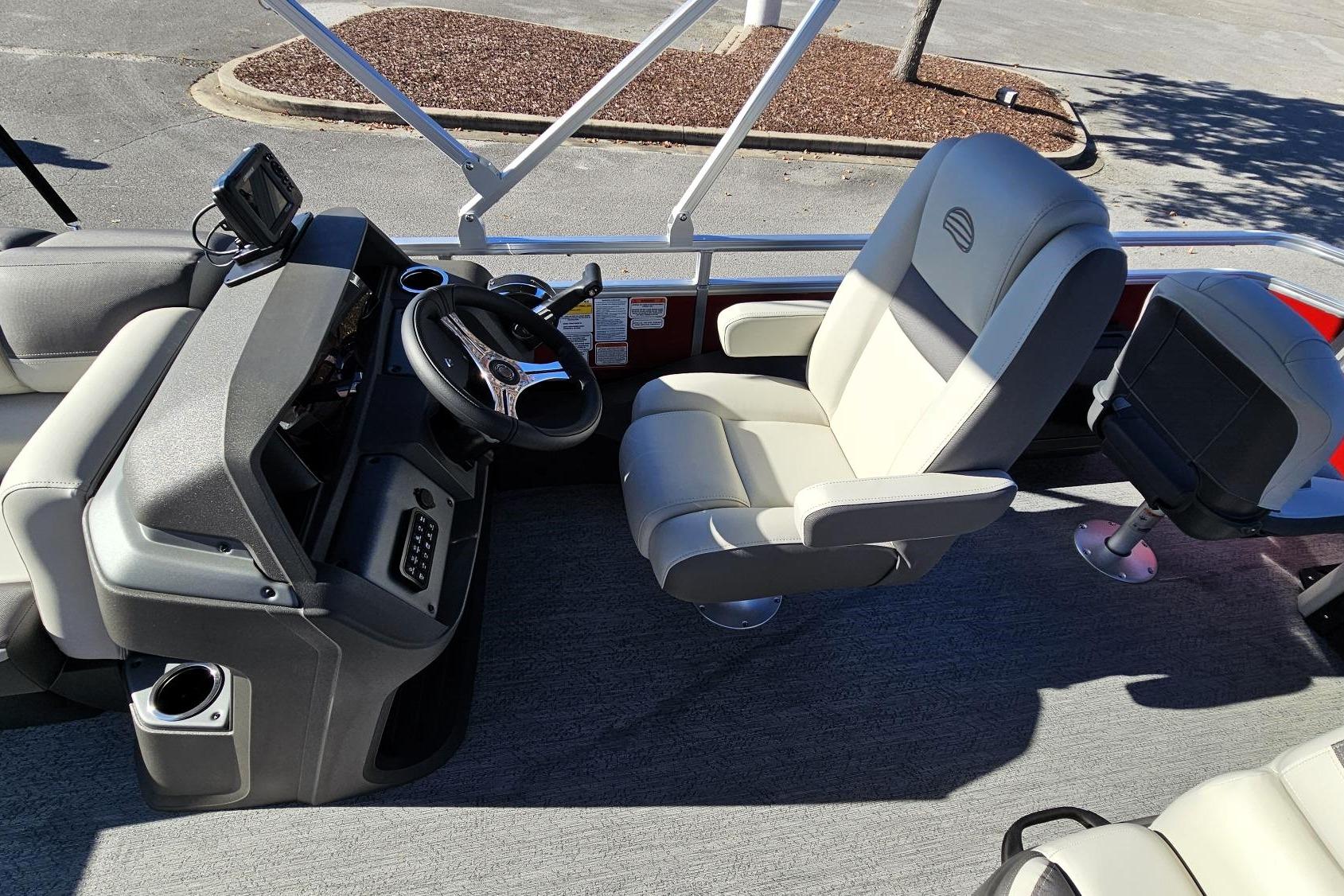 2026 Sun Tracker Fishin' Barge 22 DLX interior with steering console and comfortable seating.