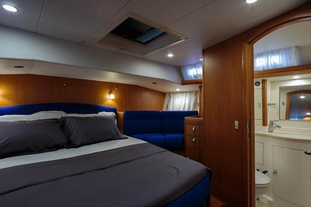 Luxurious 2004 Oyster 53 yacht cabin with cozy bed and ensuite bathroom.