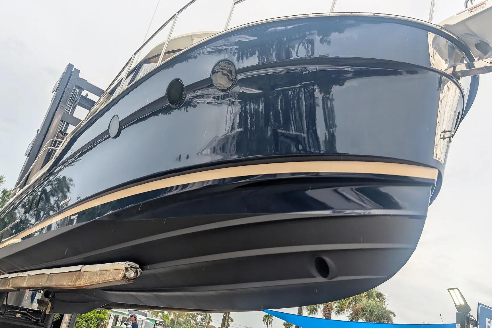 2015 Ranger Tugs R-29 S boat hull, dark blue with beige stripe, on lift.
