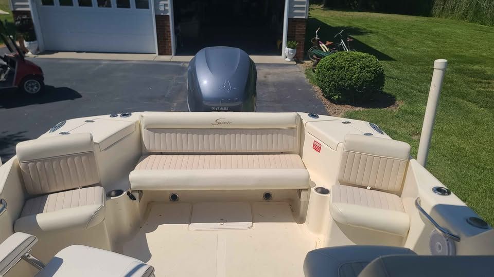 The image shows the cockpit of a 2005 Scout 222 Dorado boat with beige seating.