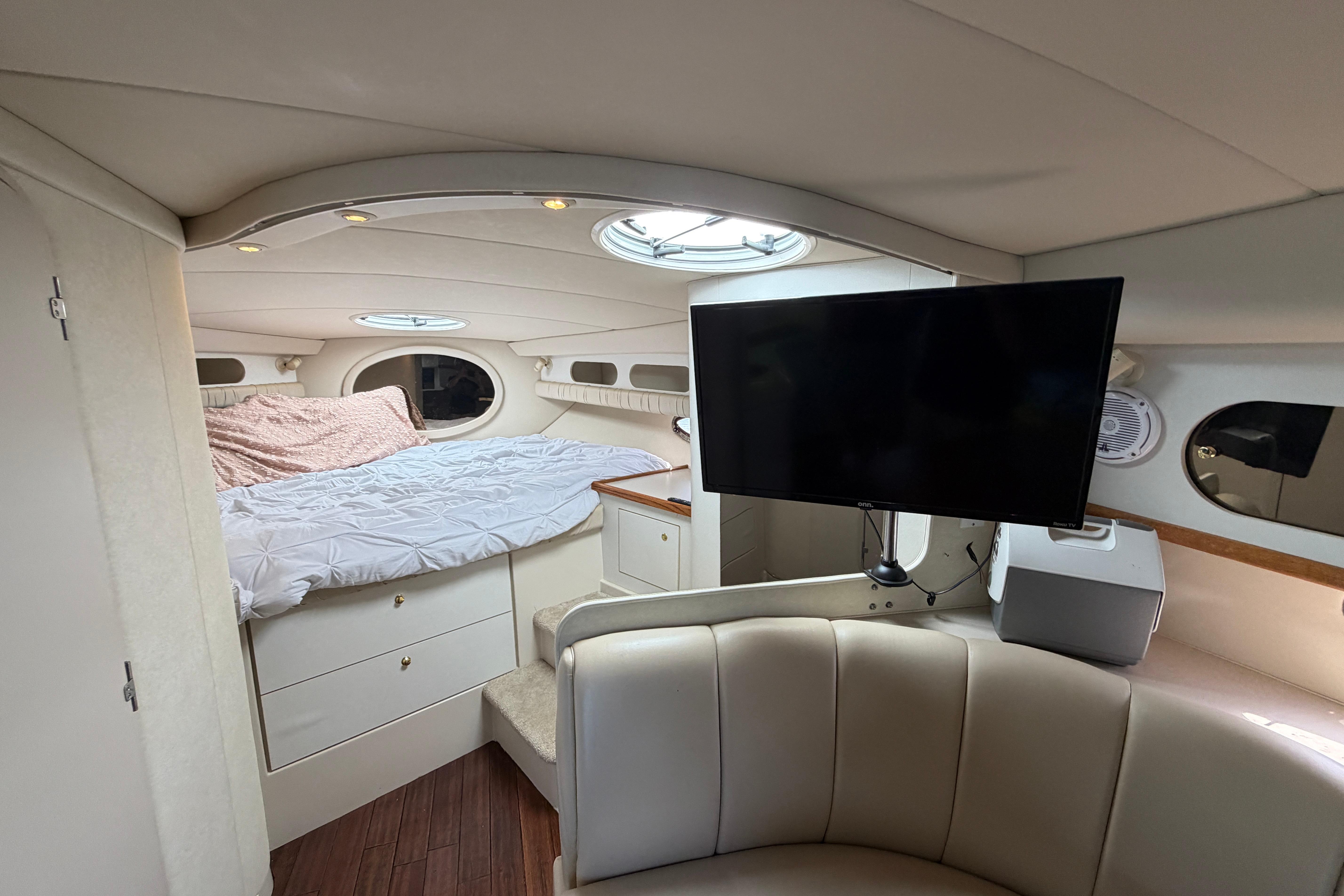 Luxurious 1997 Cruisers 3575 yacht interior with bed, TV, and seating area.
