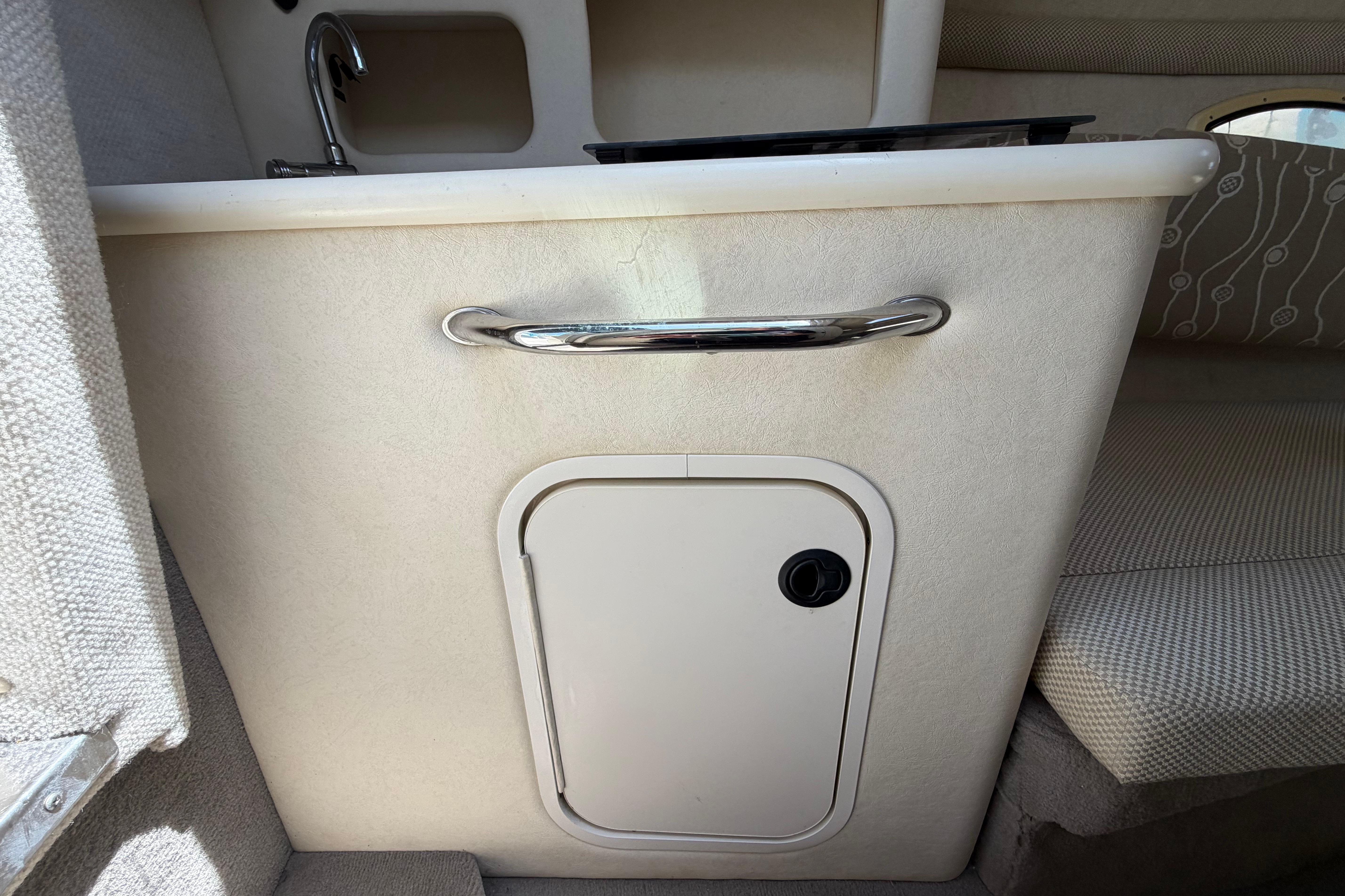 2006 Sea Ray 250 Amberjack cabin interior with sink and storage compartment.