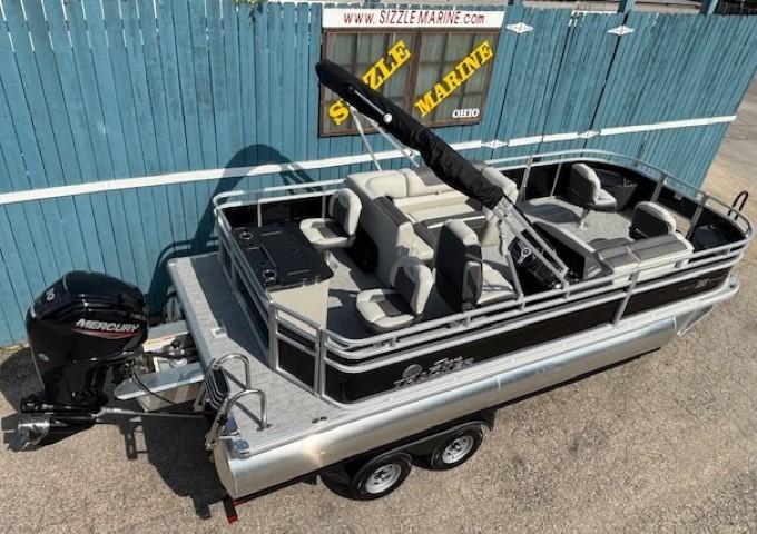 2026 Sun Tracker Fishin' Barge 20 DLX pontoon boat with Mercury engine, parked on trailer.