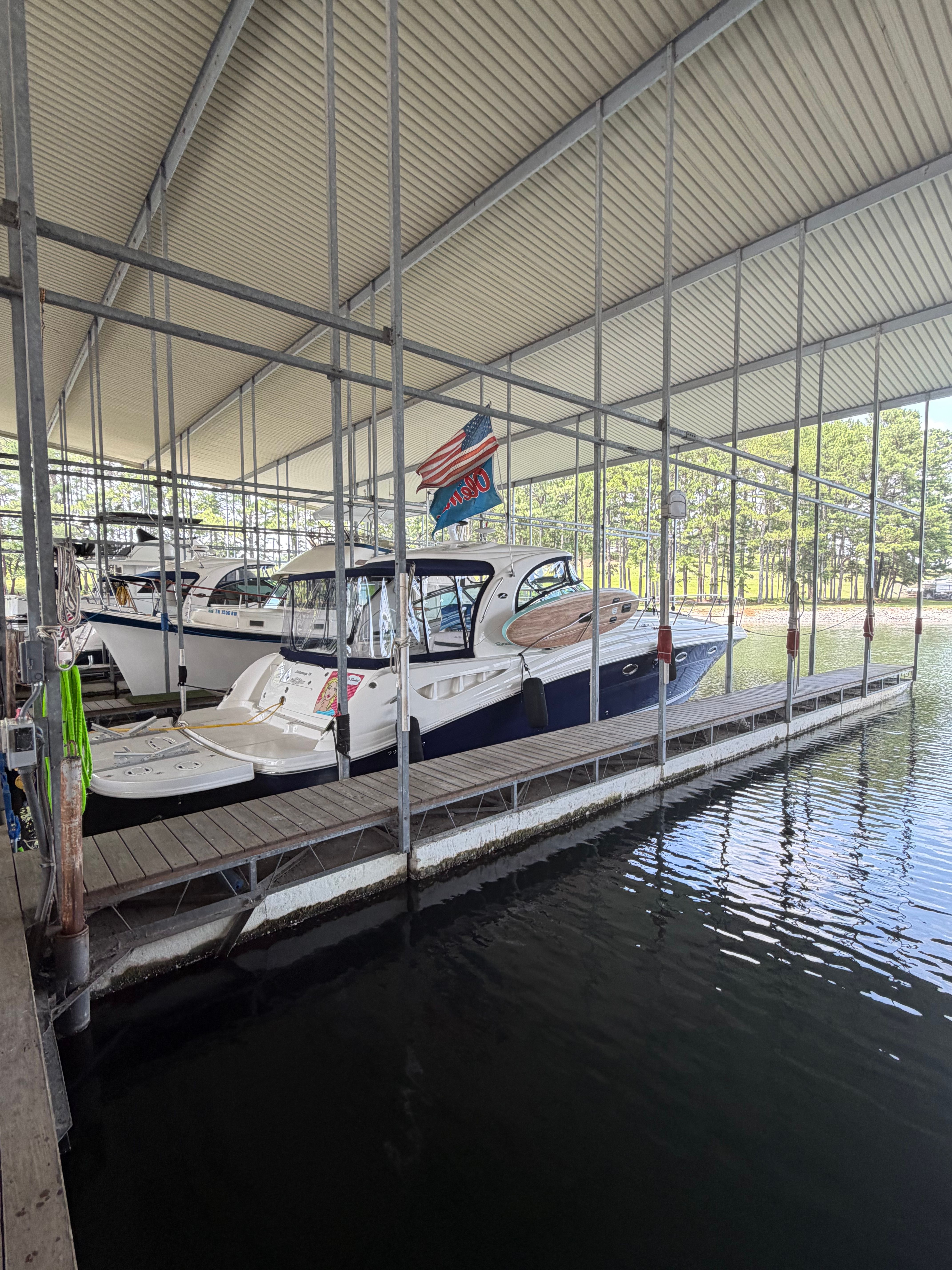 A 2005 Sea Ray 420DA is docked in a covered marina.