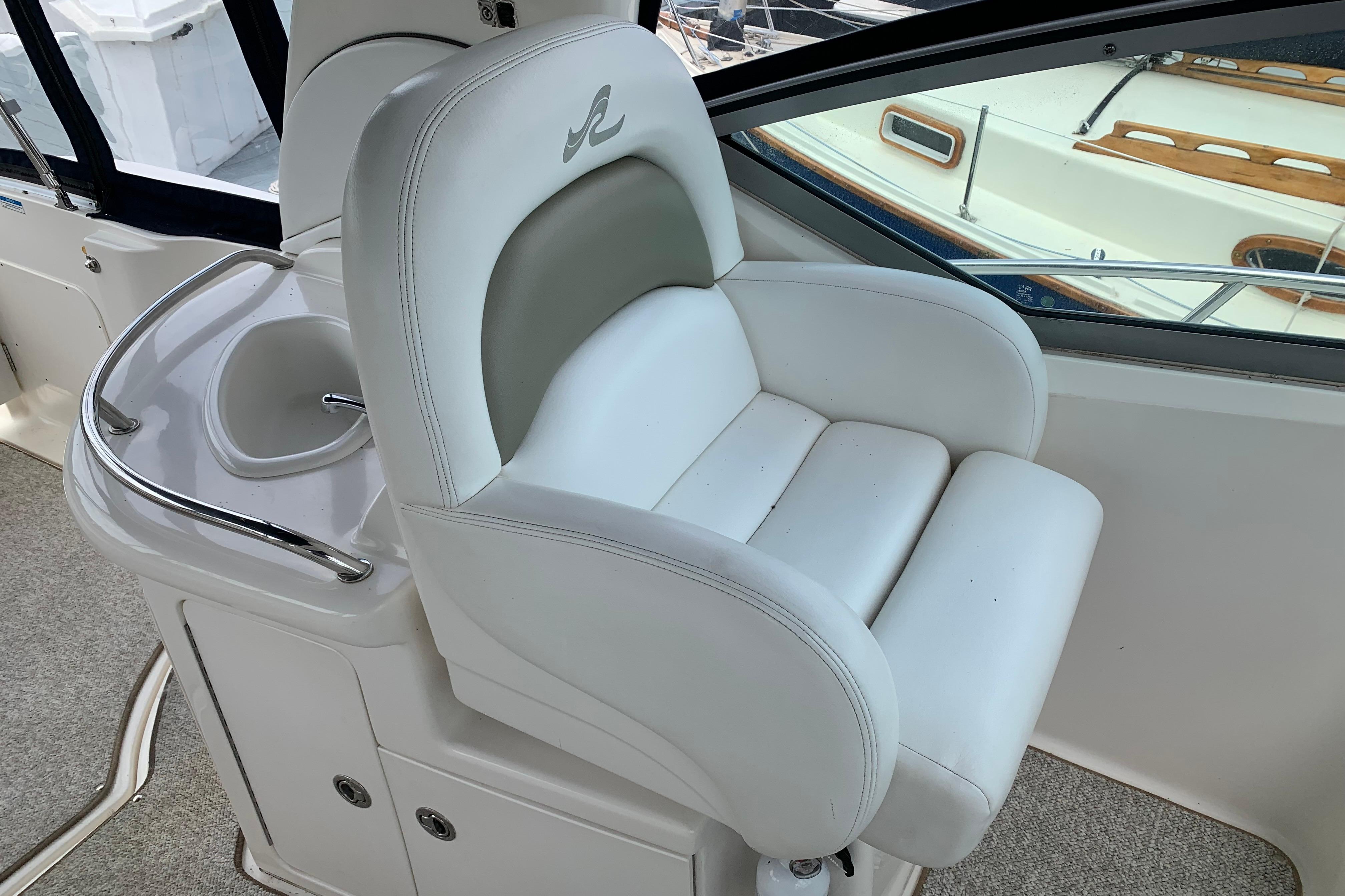 Luxurious helm seat on a 2007 Sea Ray 340 Sundancer yacht, featuring sleek white upholstery.