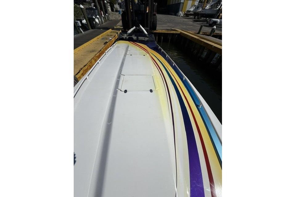 2000 Fountain 47 Lightning boat with colorful stripes docked at a marina.