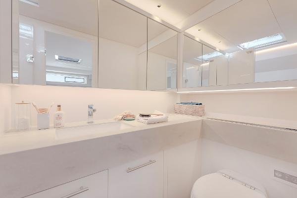 Modern bathroom interior in 2025 Lagoon SIXTY 5 yacht, featuring sleek white design and ample storage.