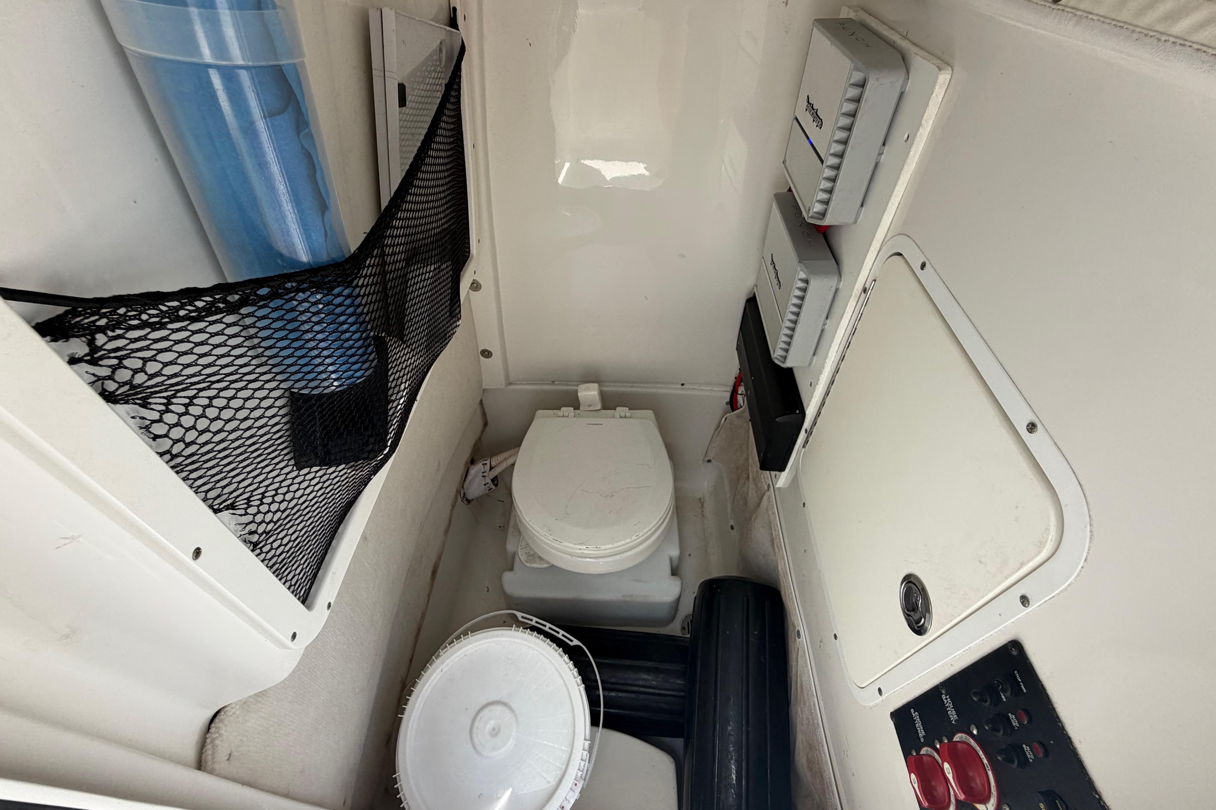 Interior of 2019 Sea Hunt Gamefish 27 Coffin Box with marine toilet and storage.