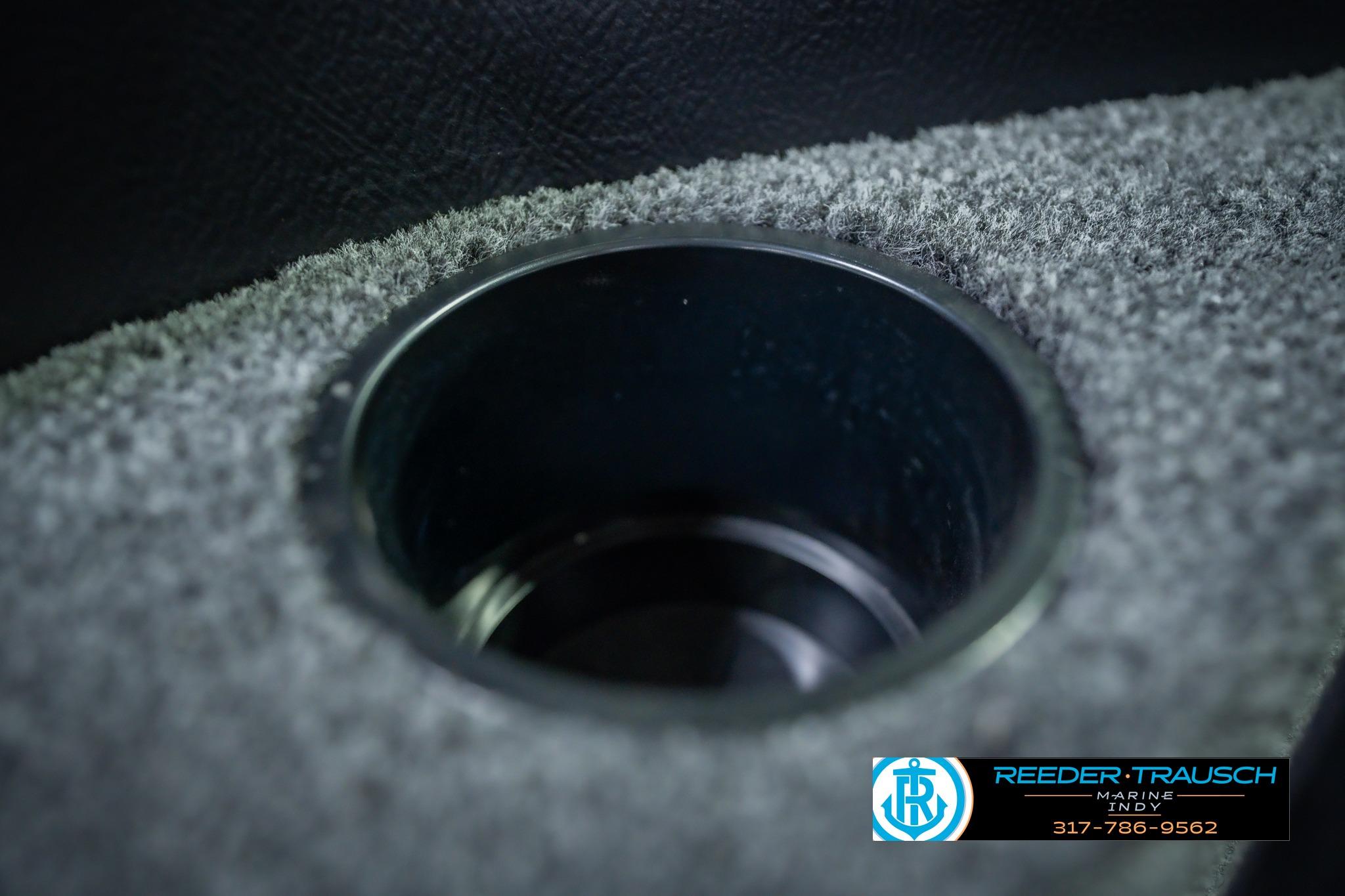 Cup holder in 2026 Lund 1775 Impact XS boat, featuring carpeted interior.
