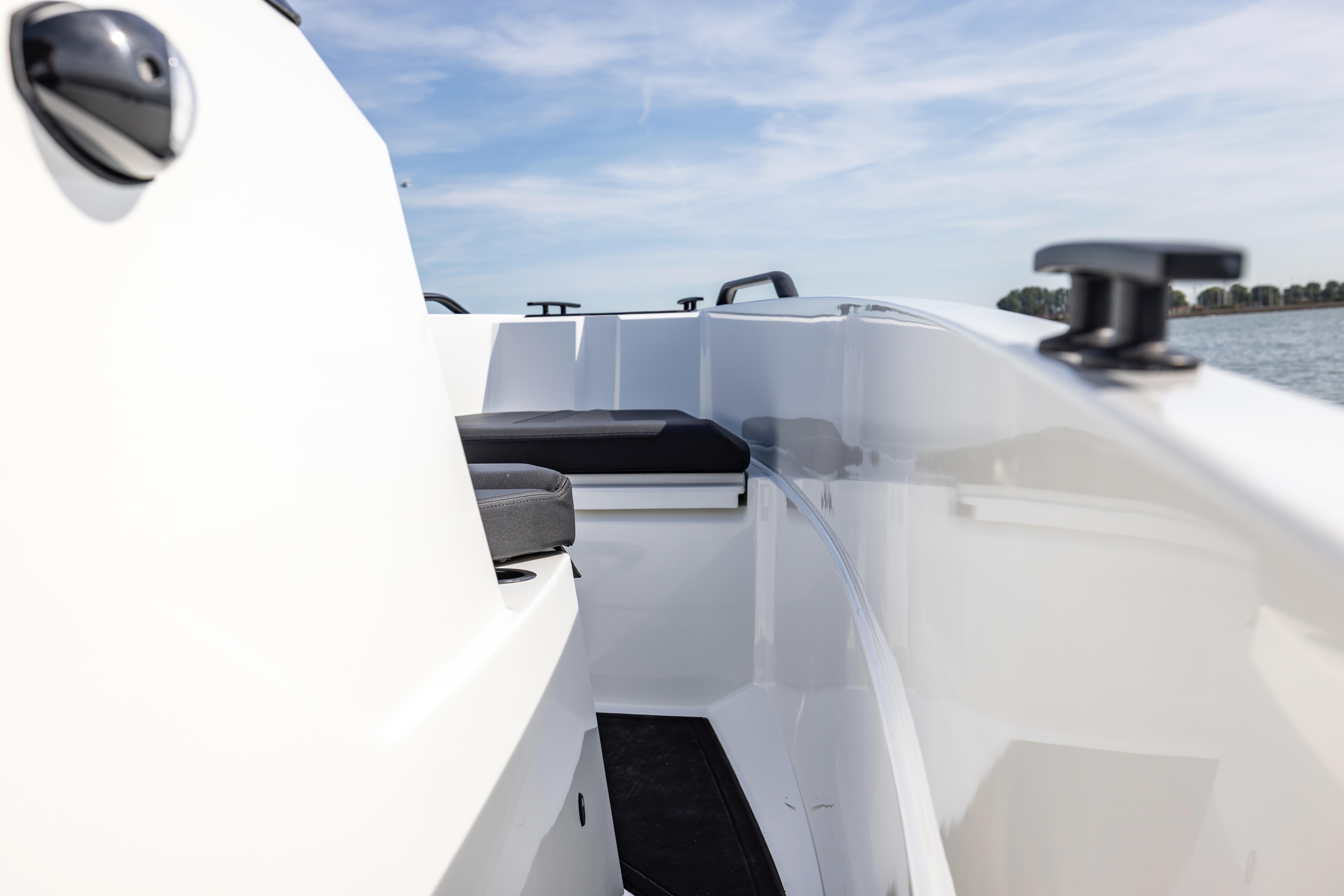 2022 Iron 707 boat interior with sleek white design and black seating, under a clear blue sky.