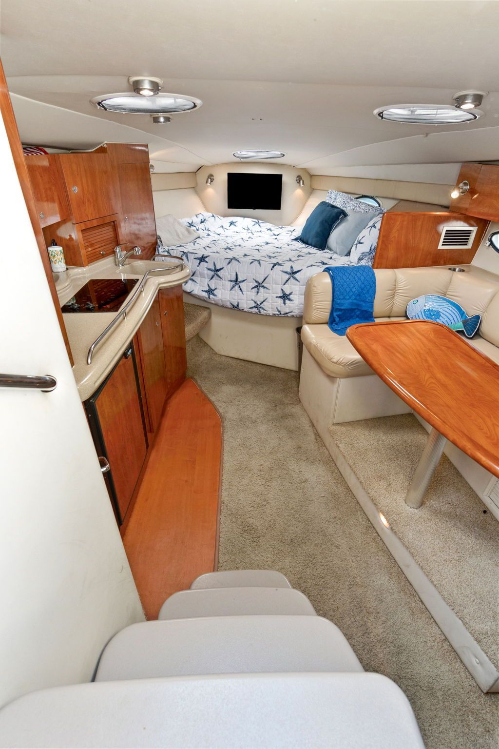 Interior of the 2007 Larson Cabrio 330 with kitchen, seating area, and sleeping space.