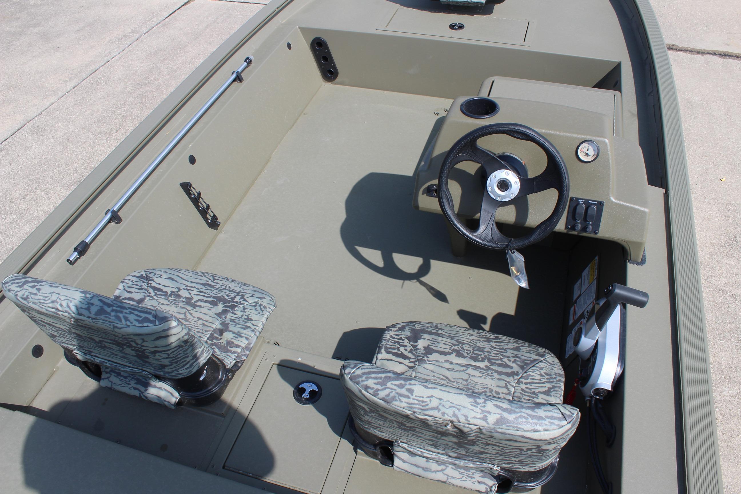 2026 Tracker Grizzly 1754 SC boat interior with steering console and camo-patterned seats.