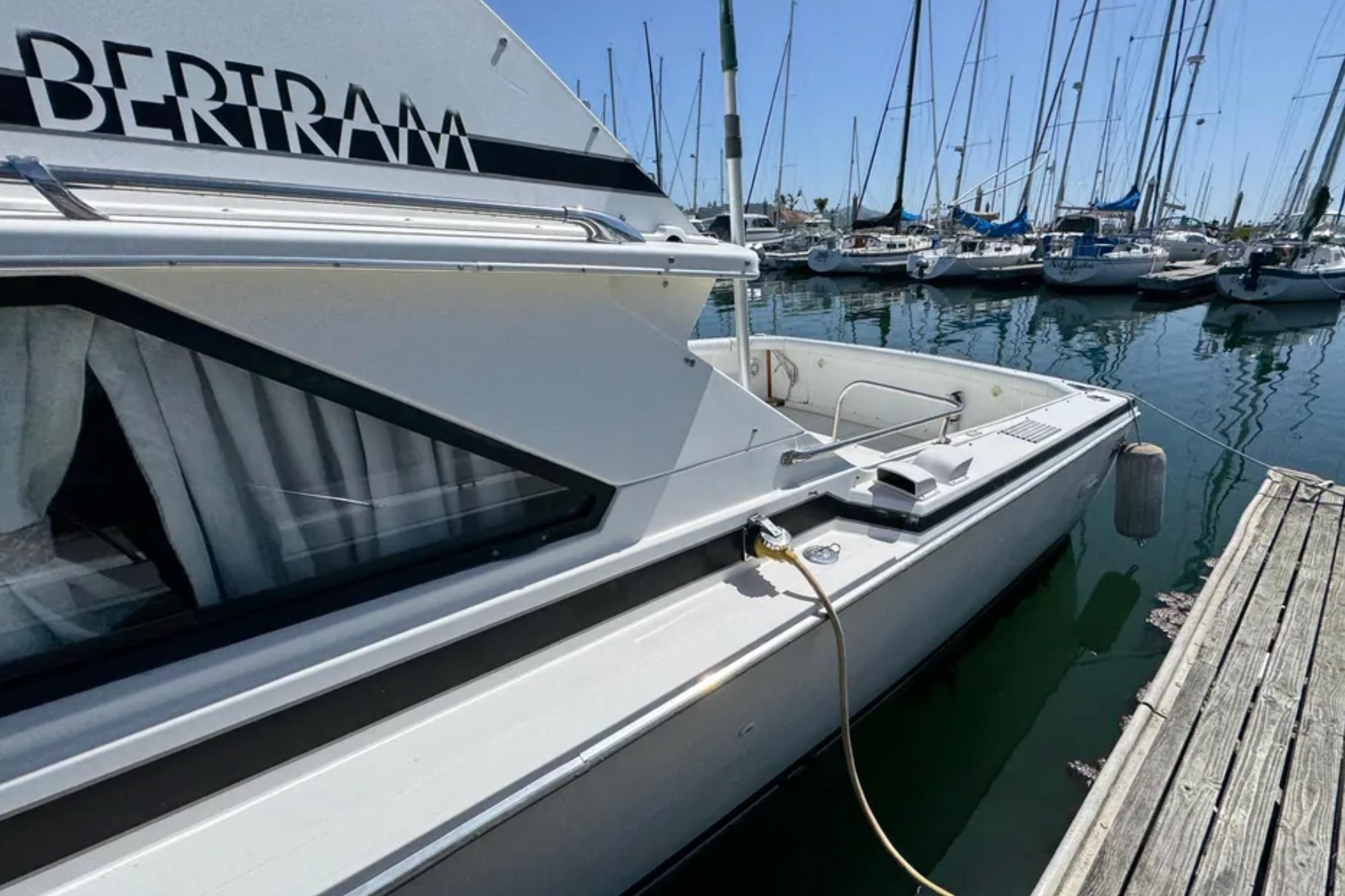 1988 Bertram 28 Sport Fisherman docked at marina, surrounded by sailboats.