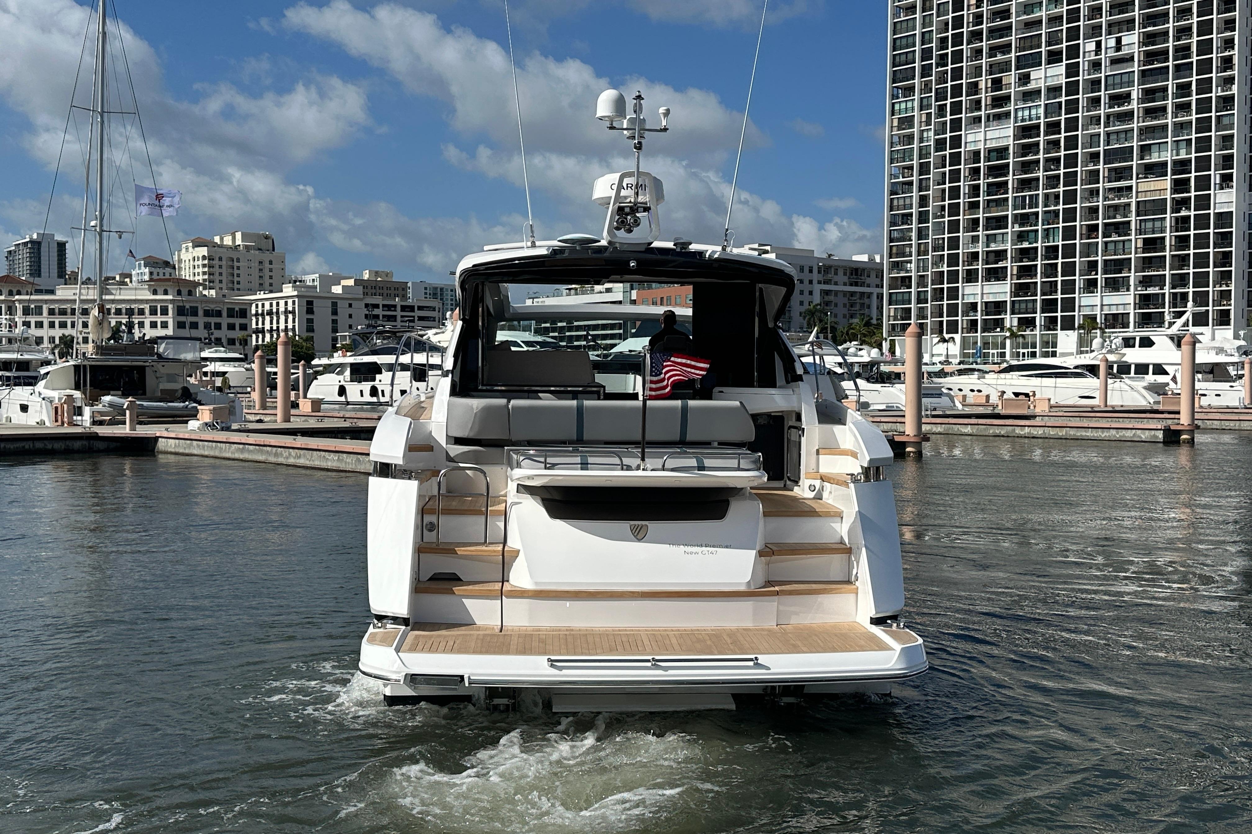 2026 Fairline Targa 47 GT yacht docked in a marina, cityscape background.