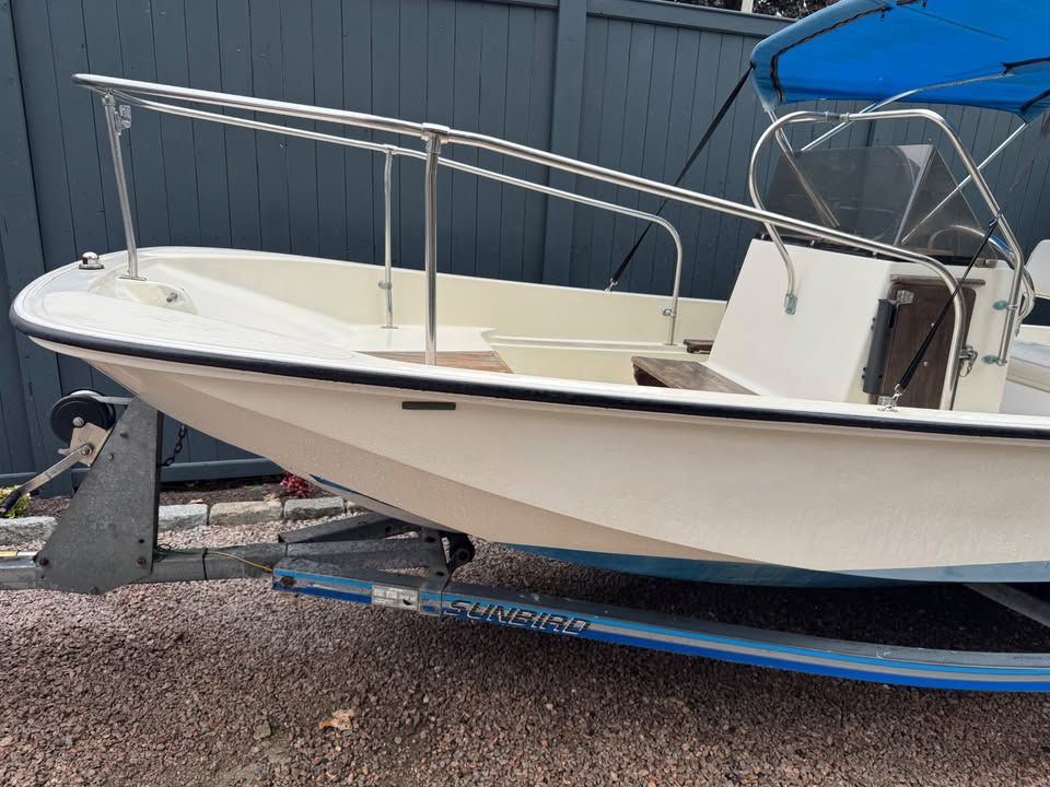 A 1976 Boston Whaler 17 Montauk on a trailer. It features a blue sunshade.