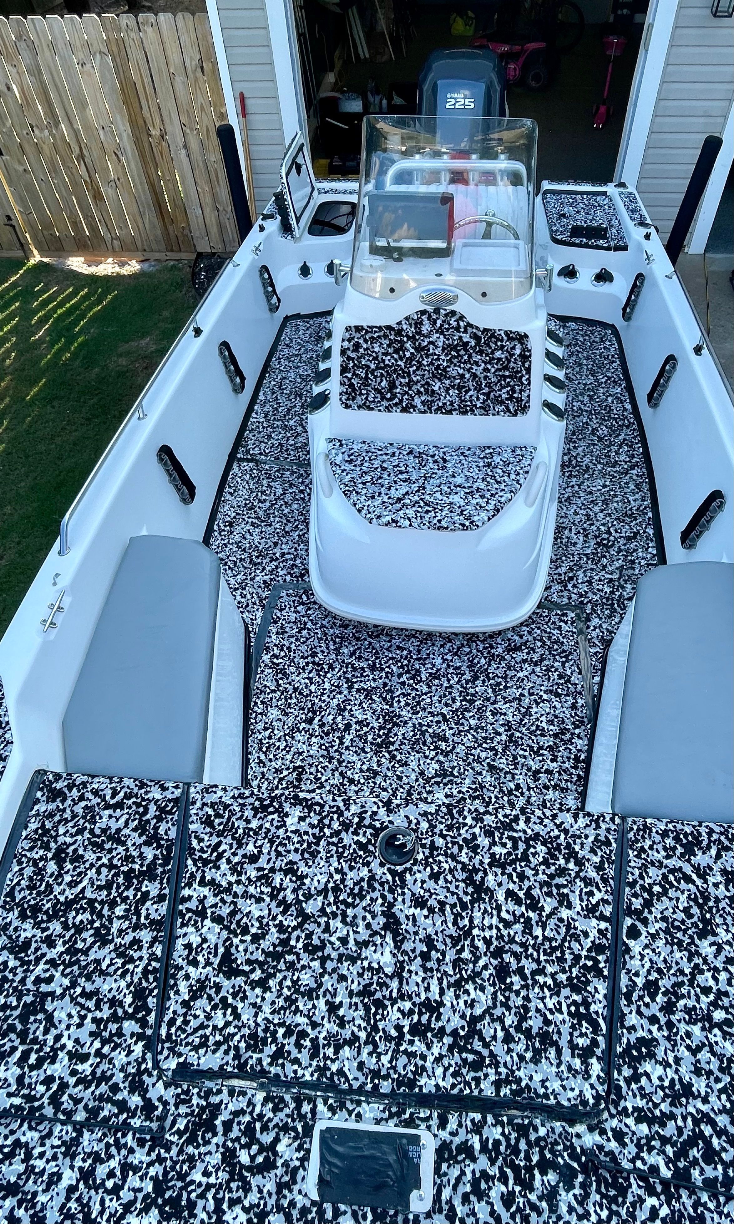 2006 Mako 2101 Inshore with patterned deck, steering console, and gray seat cushions.