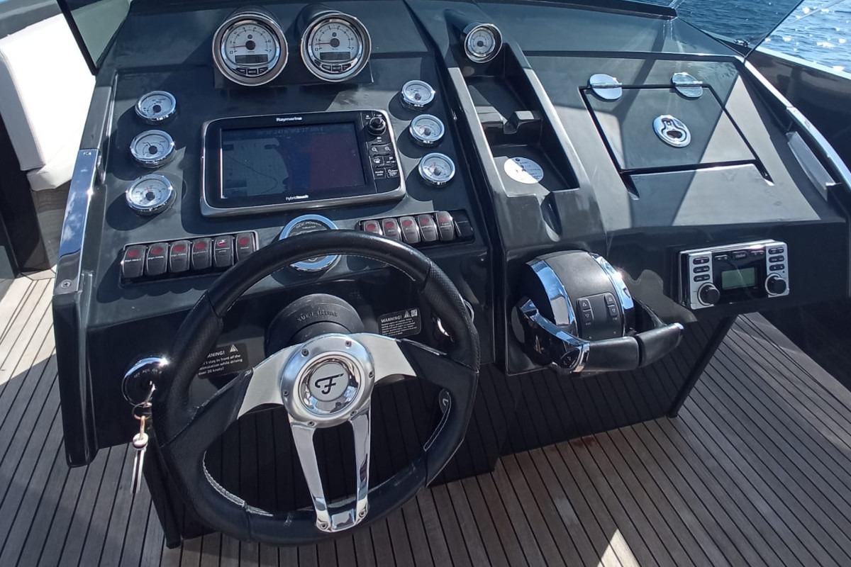 Cockpit of 2015 Frauscher 1017 boat with steering wheel and navigation controls.