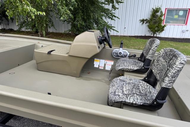 2026 Tracker Grizzly 1754 SC boat interior with camo seats and steering console.