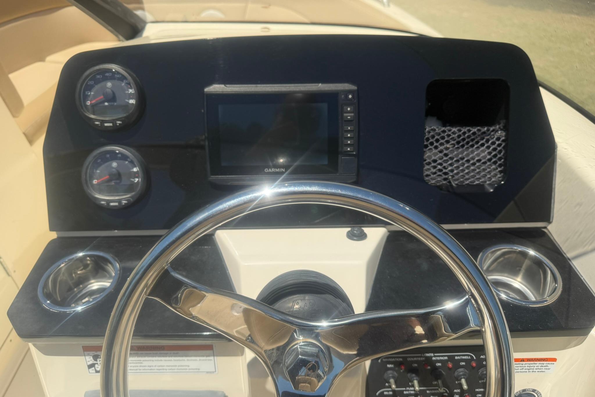 2021 Scout 215 Dorado boat dashboard with steering wheel and Garmin display.