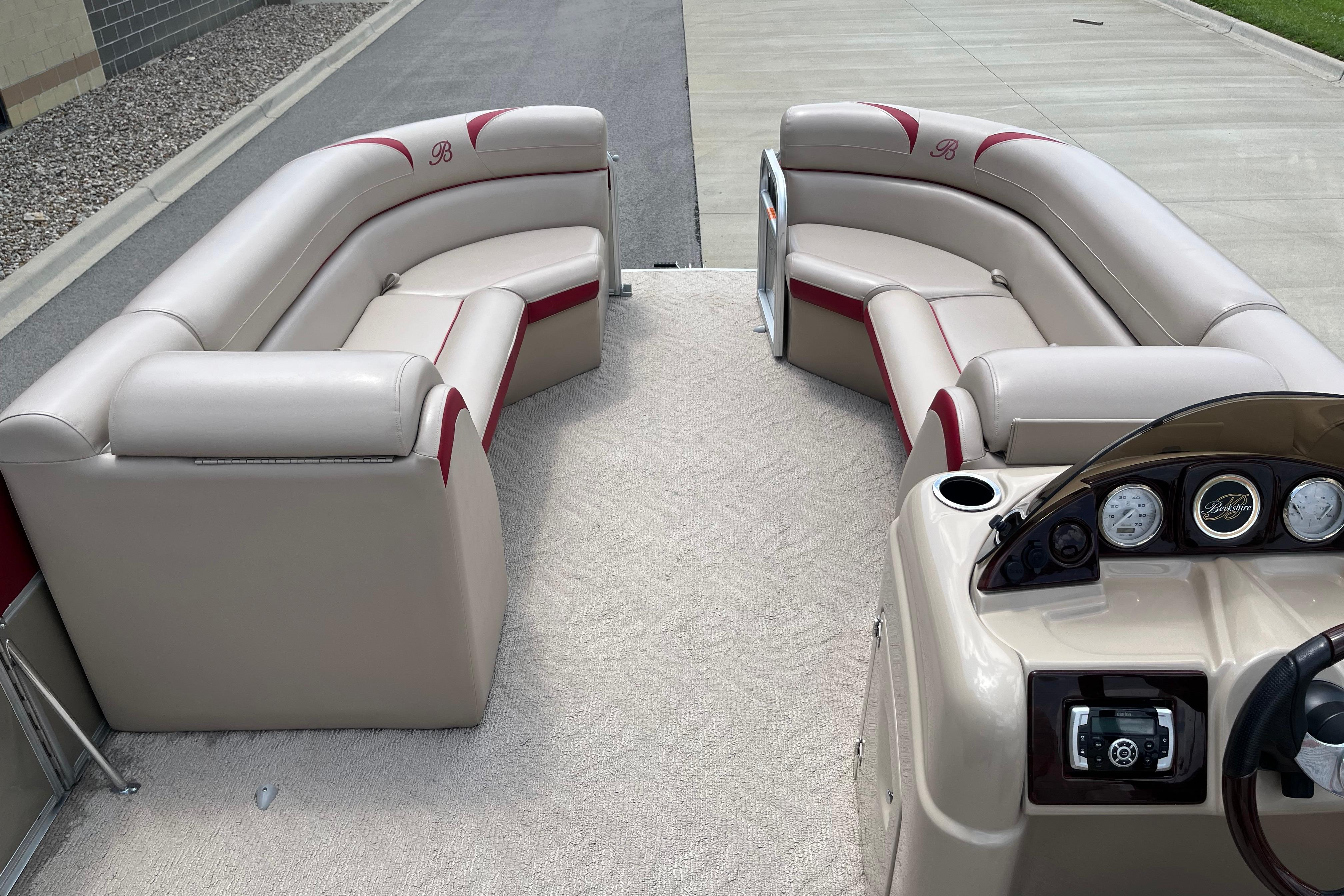 2013 Berkshire 230CL CTS pontoon boat interior with beige seating and dashboard.