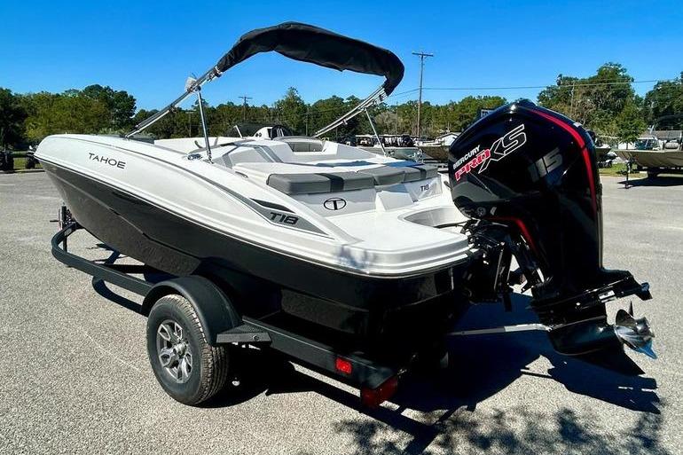 2025 Tahoe T18 boat with outboard motor on trailer, parked outdoors.