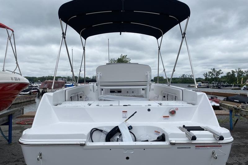 2025 Stingray 173CC boat with canopy, docked under cloudy skies.