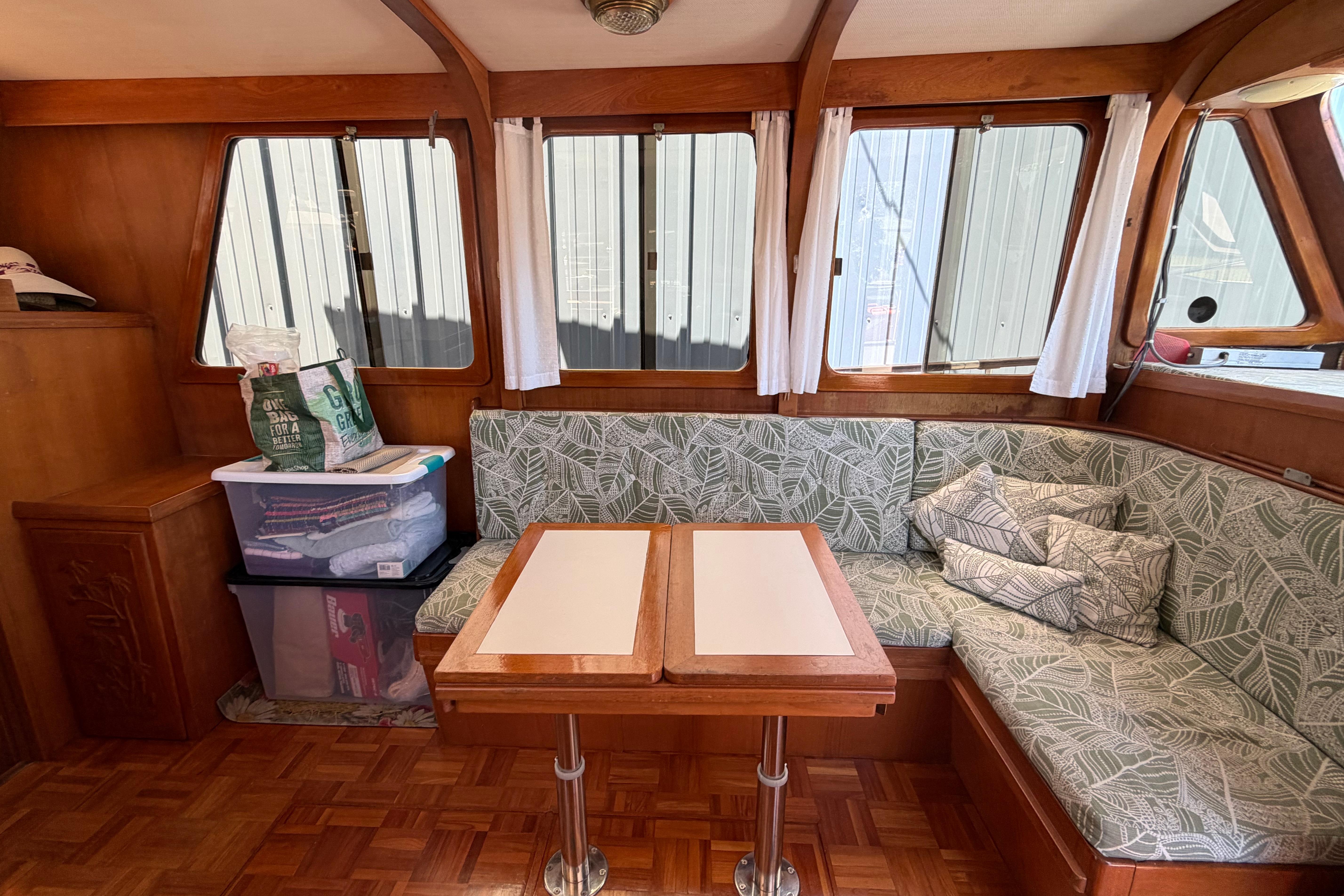 Interior of 1987 Marine Trader 36 with cushioned seating and wooden table.