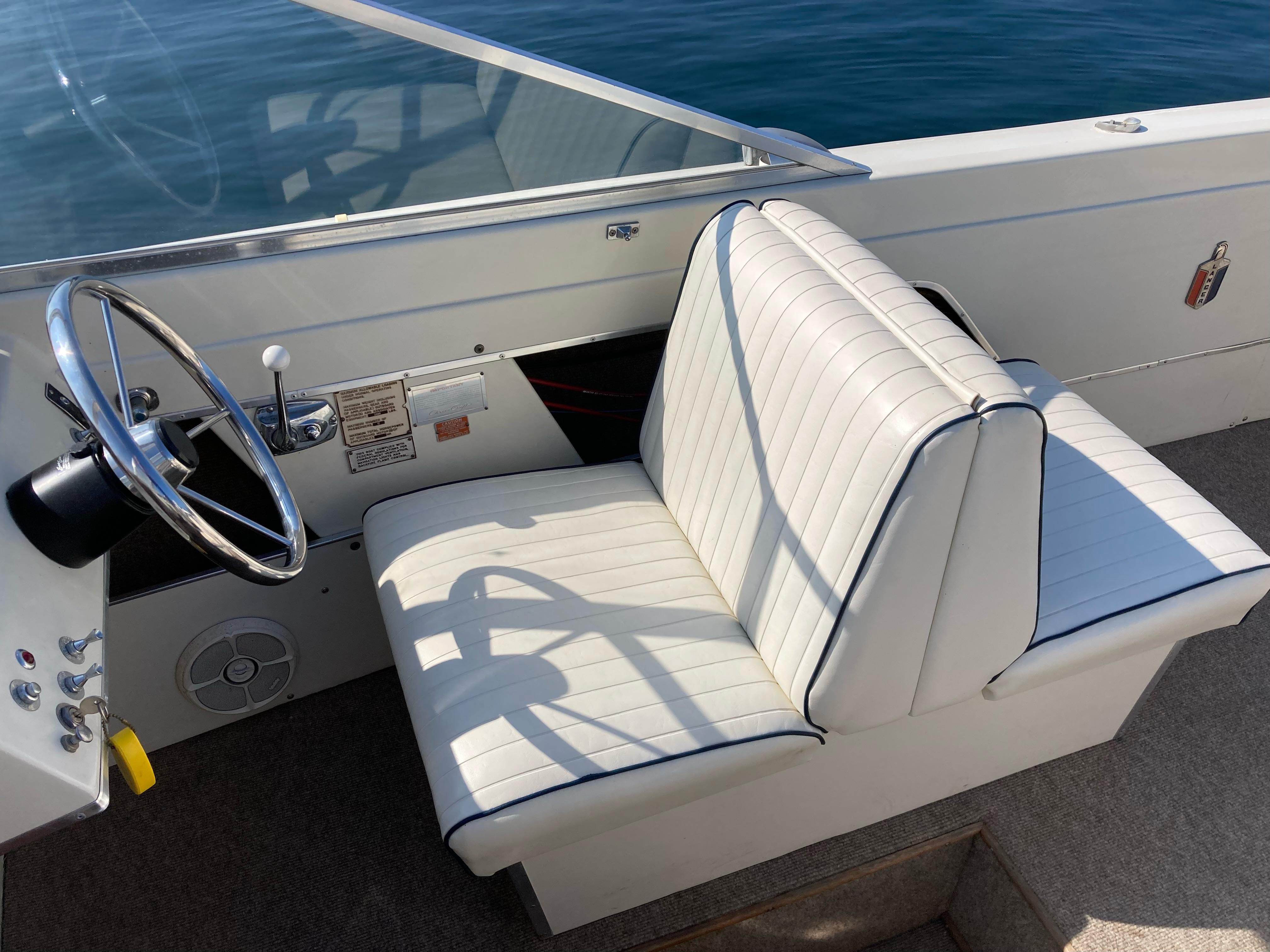 1970 Chris-Craft Lancer 23 boat interior with white leather seats and steering wheel.