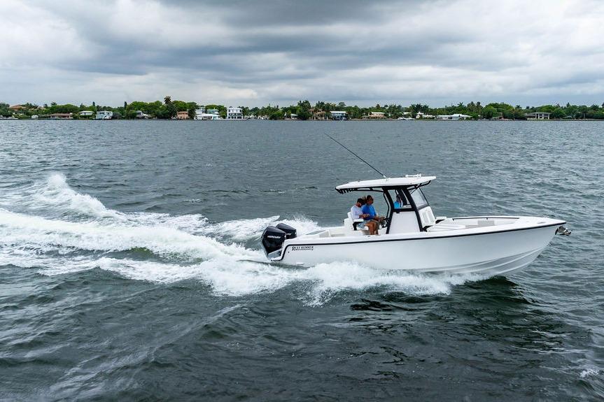 2027 Reef Runner 280 boat cruising on a lake under cloudy skies.