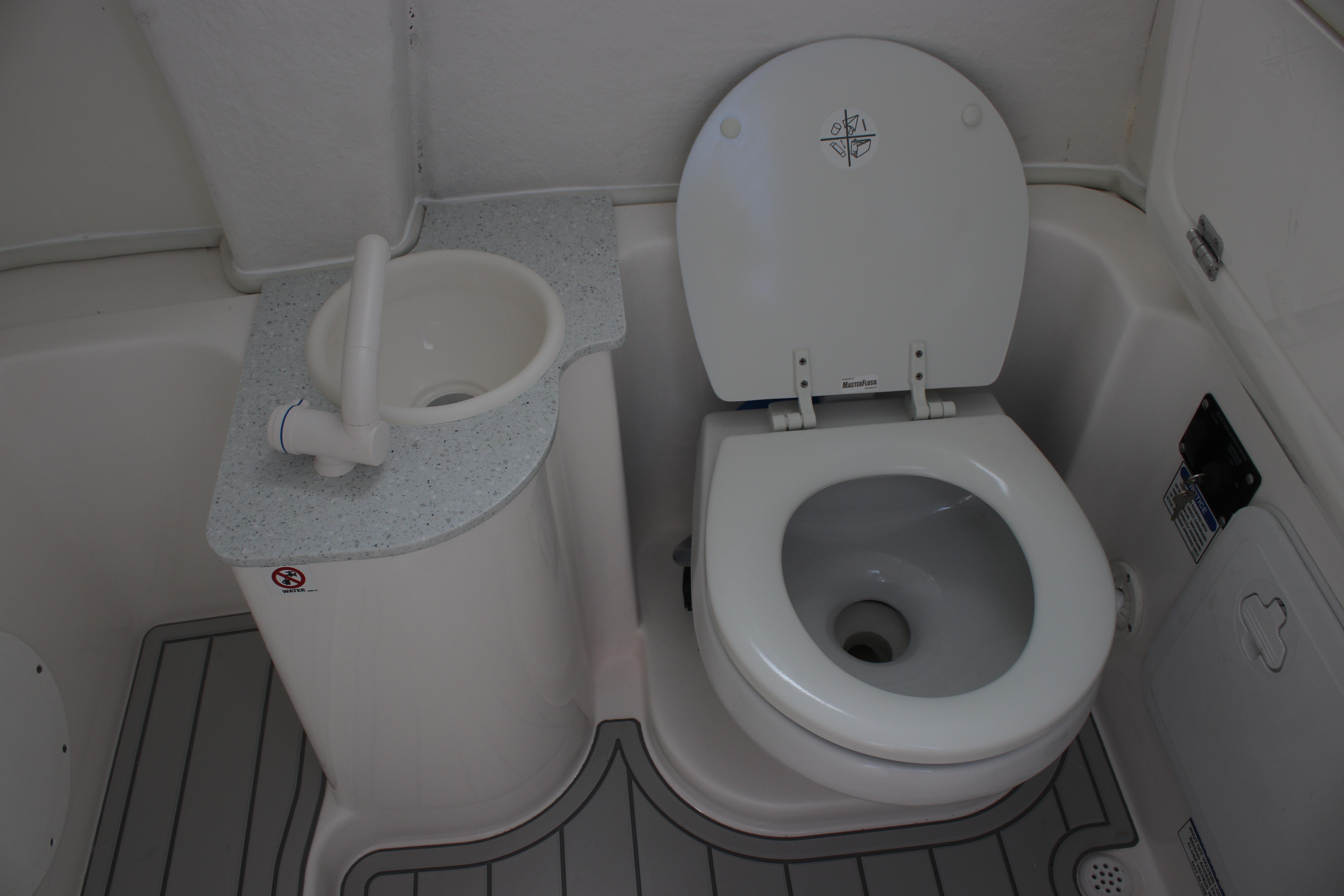 2026 Sea Fox 268 Commander boat bathroom with toilet and compact sink.