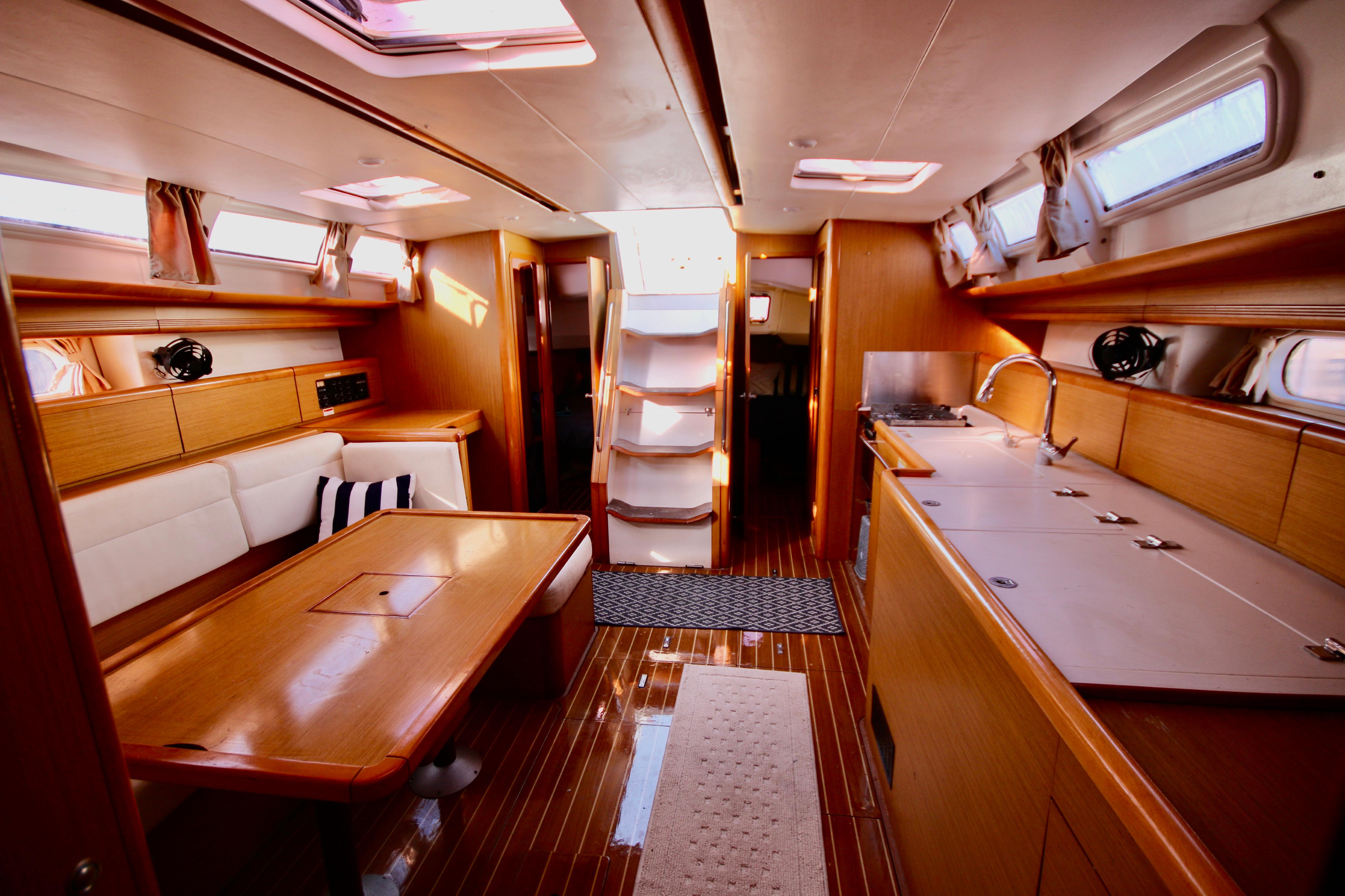 Interior of 2009 Jeanneau Sun Odyssey 44i yacht, featuring a spacious, elegant wooden design.