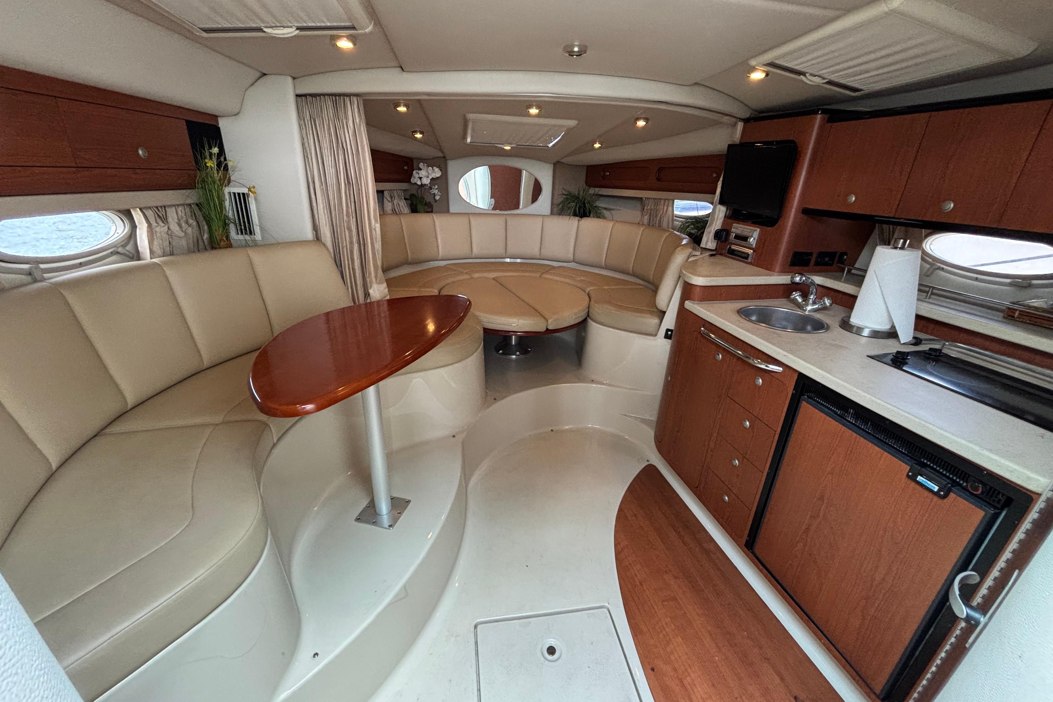 Luxurious interior of 2004 Chaparral Signature 330 yacht with seating, kitchenette, and modern amenities.