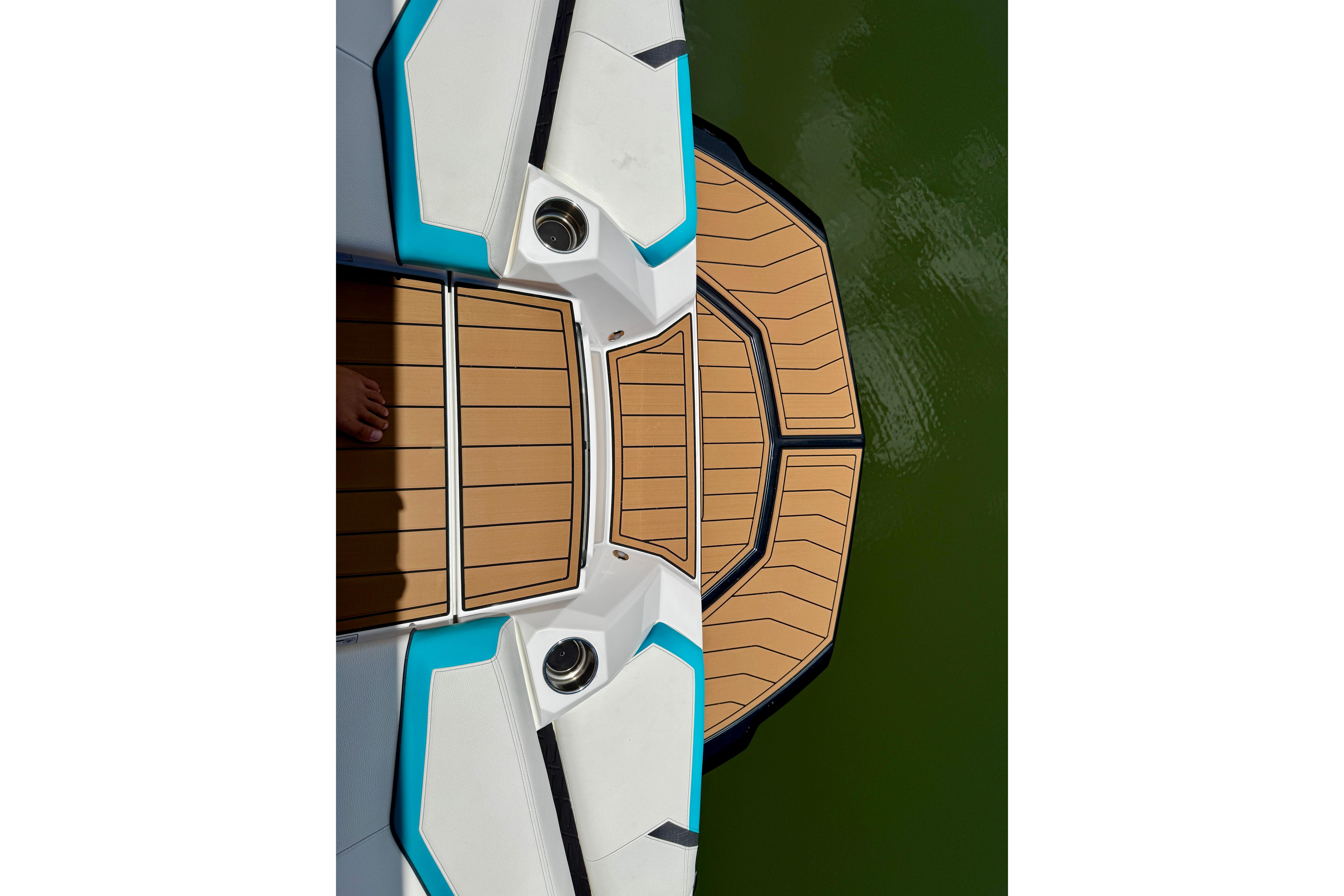 2024 Nautique Super Air Nautique GS20 boat deck with teak finish on green water.
