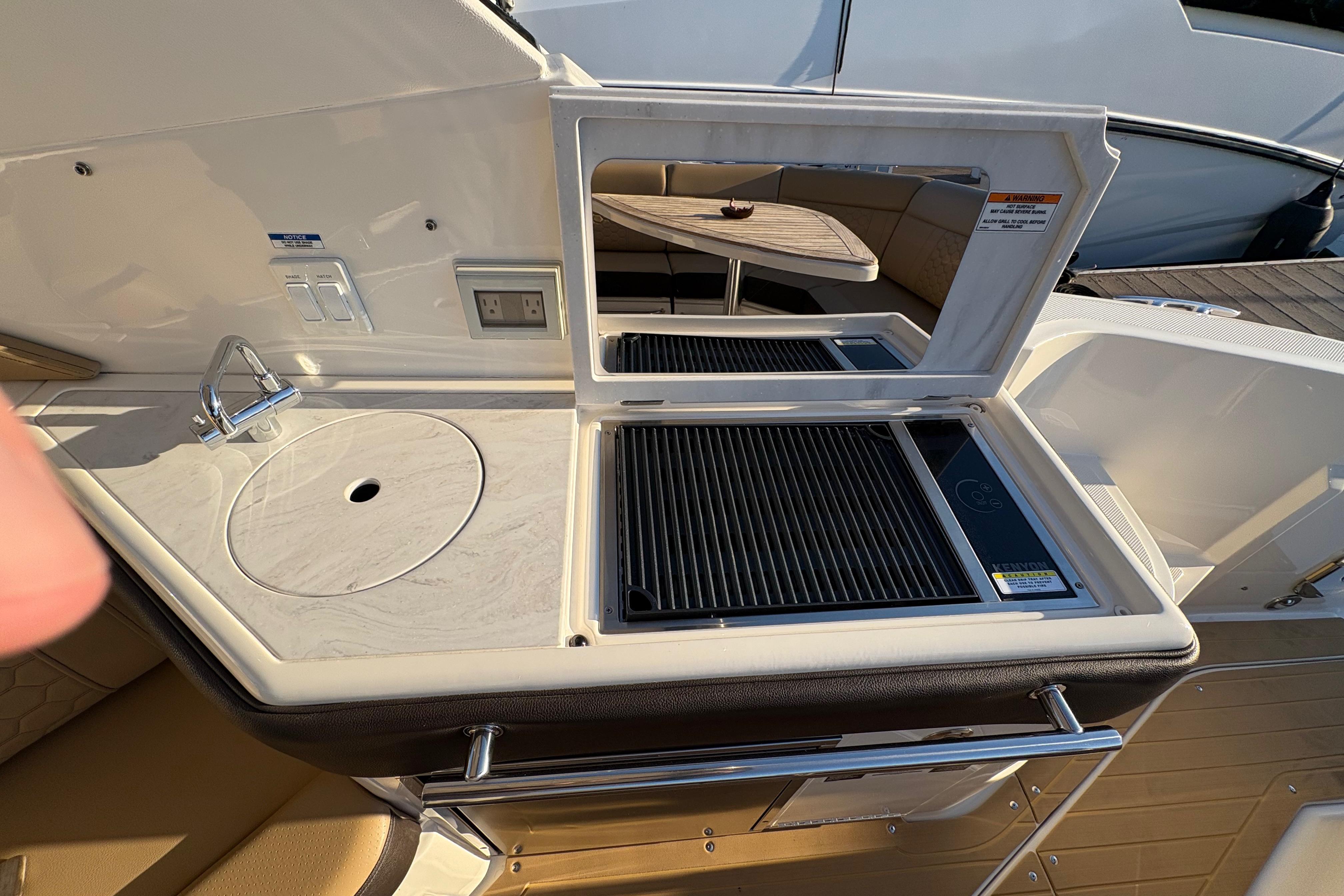 Outdoor kitchenette on 2022 Sea Ray Sundancer 320 yacht with sink and grill.