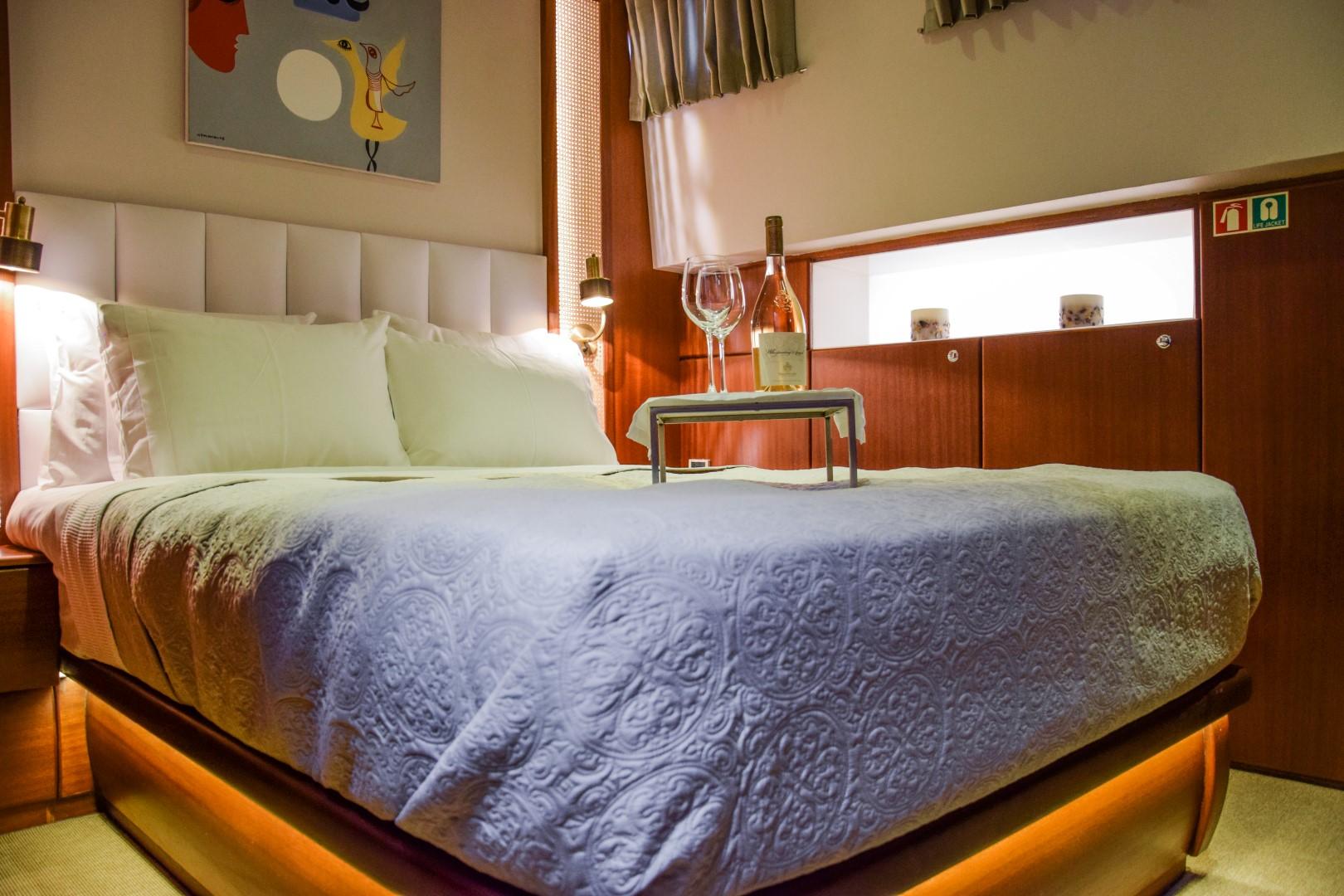 Luxurious bedroom on a 2007 Custom 34m Steel Hull Gulet with elegant decor and wine setup.