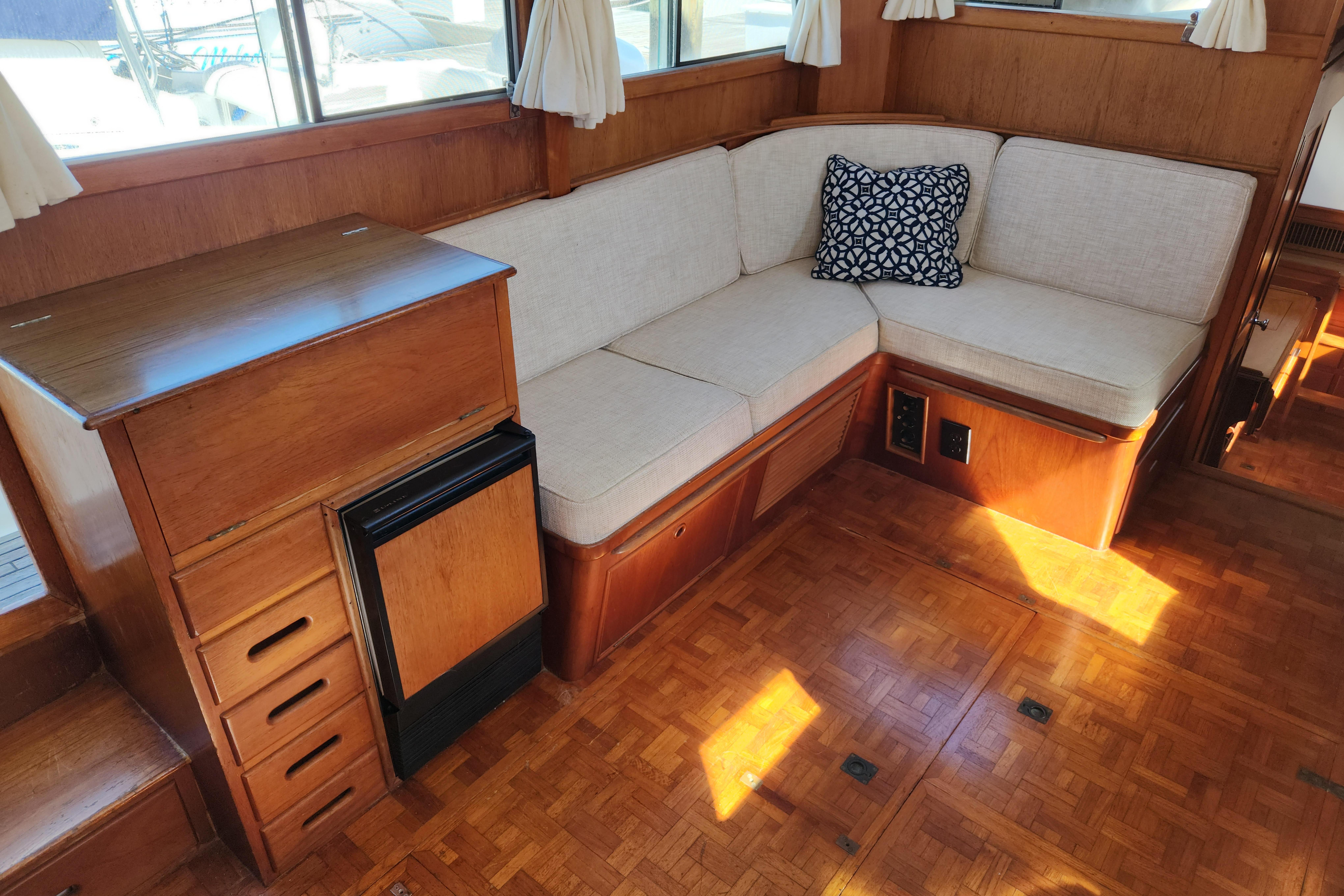 Interior of 1983 Grand Banks 36 Classic yacht with wooden cabinetry and cushioned seating.