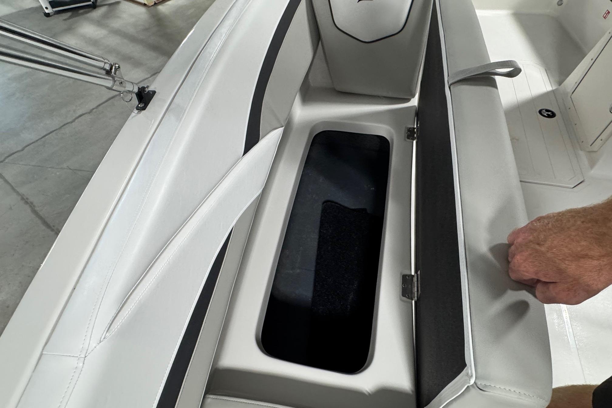 Open storage compartment in 2026 Starcraft SVX 191 OB boat with white seating.