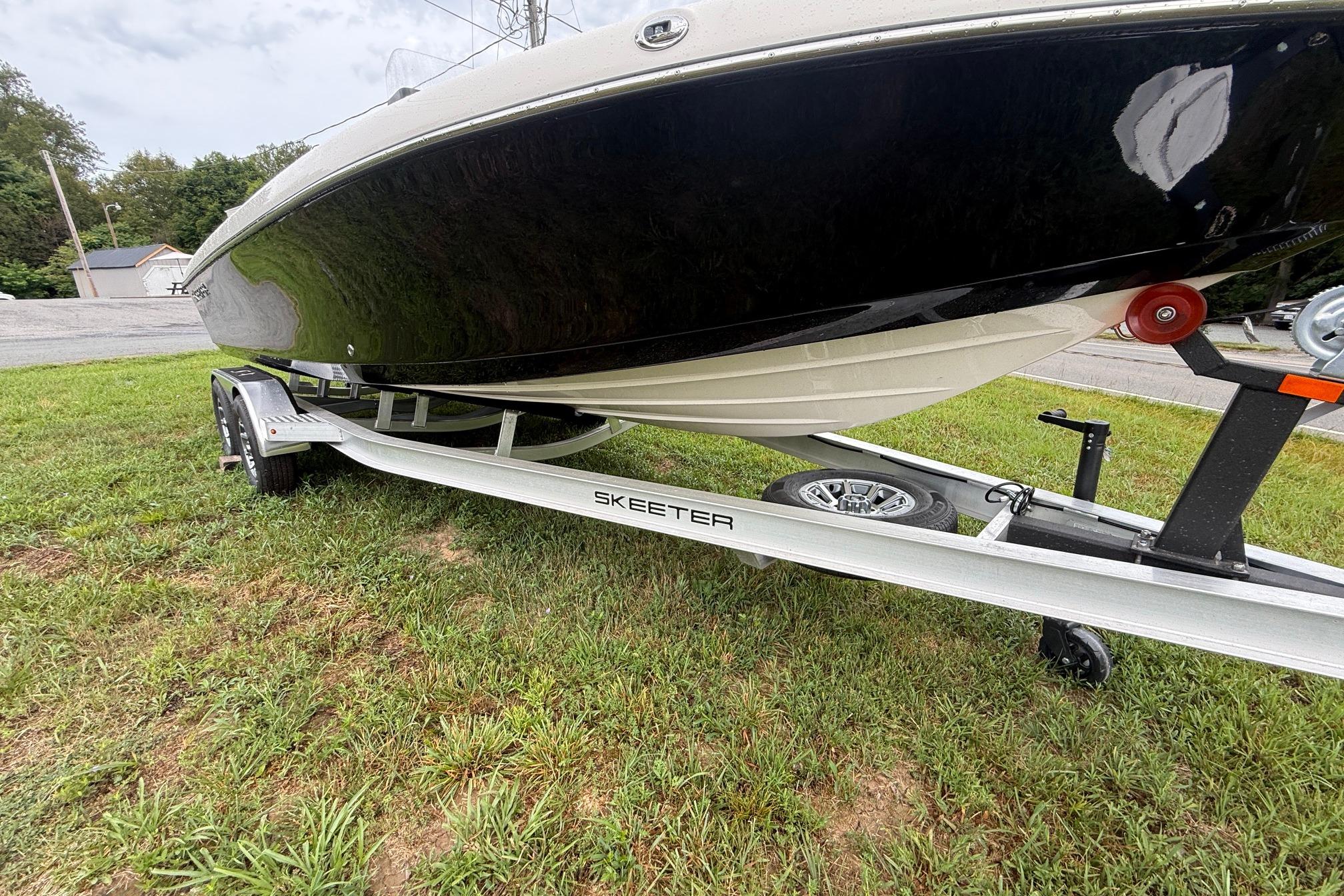 2026 Skeeter SX2350 boat on trailer, parked on grass.