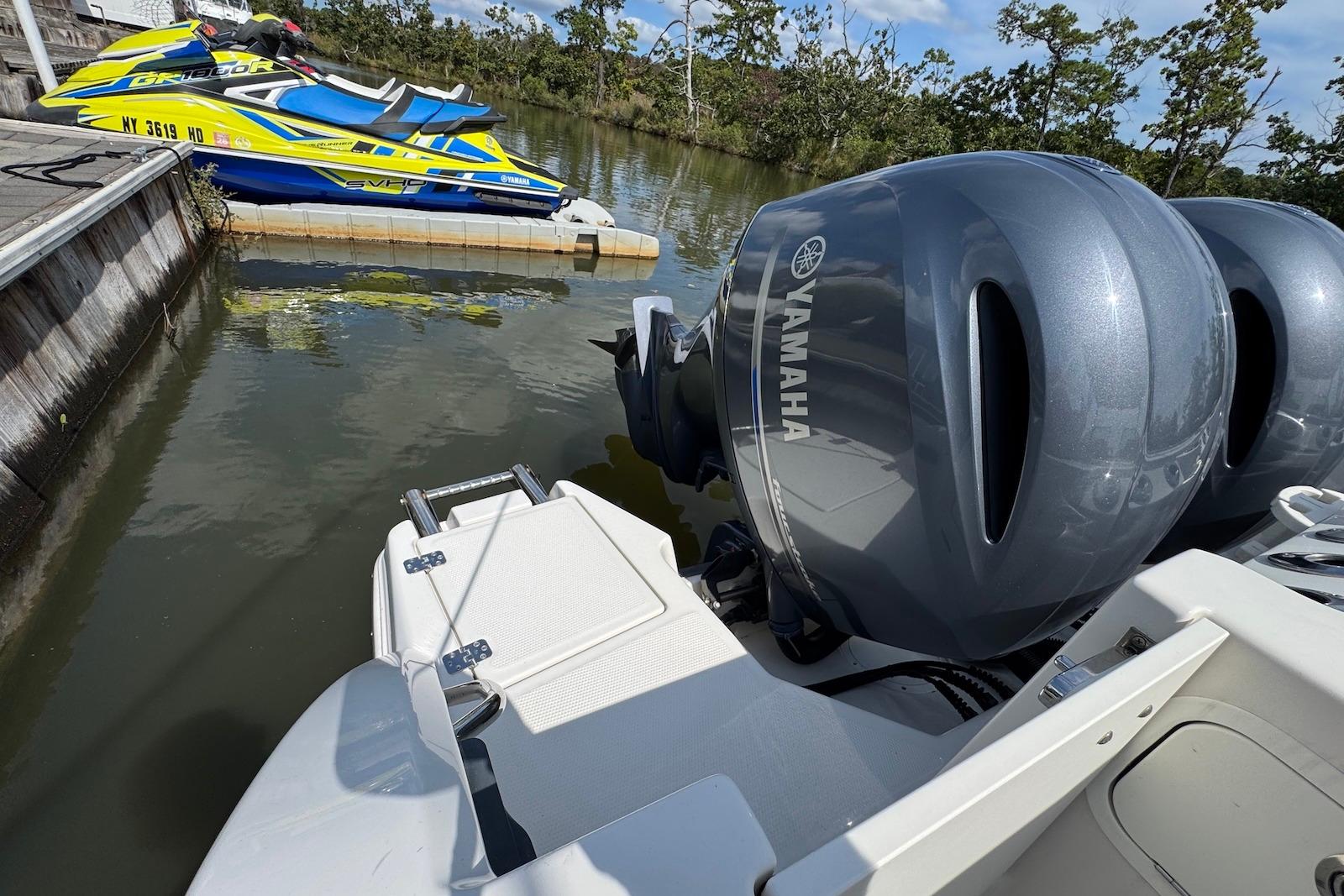 2022 Sailfish 276 DC with Yamaha outboard engines docked near jet skis.