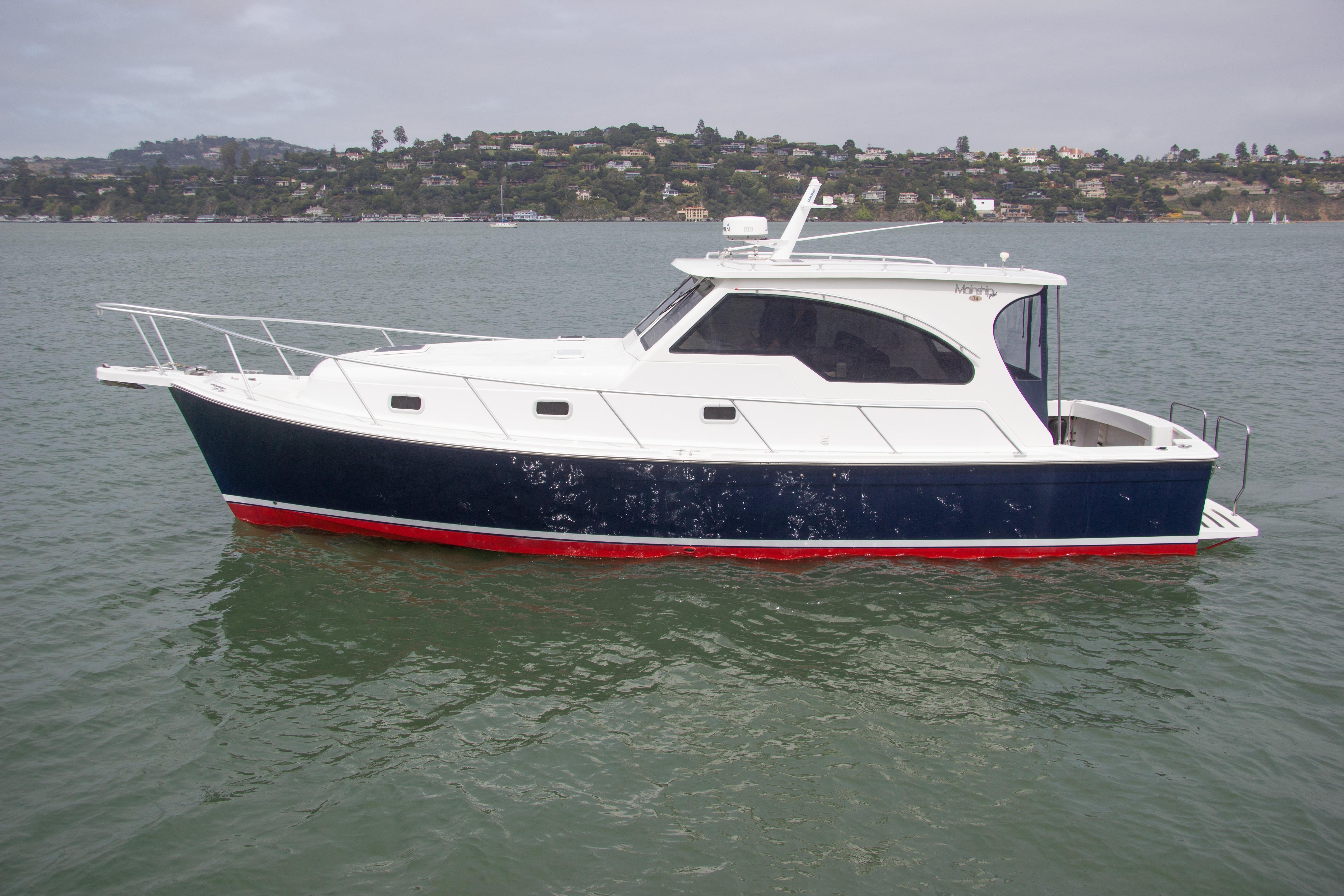 2001 Mainship Pilot 34 Sedan boat on calm water, scenic background.