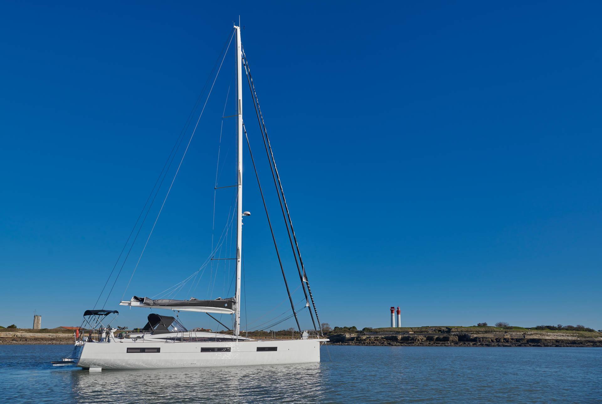 2024 Jeanneau 60 sailboat on calm water under clear blue sky.