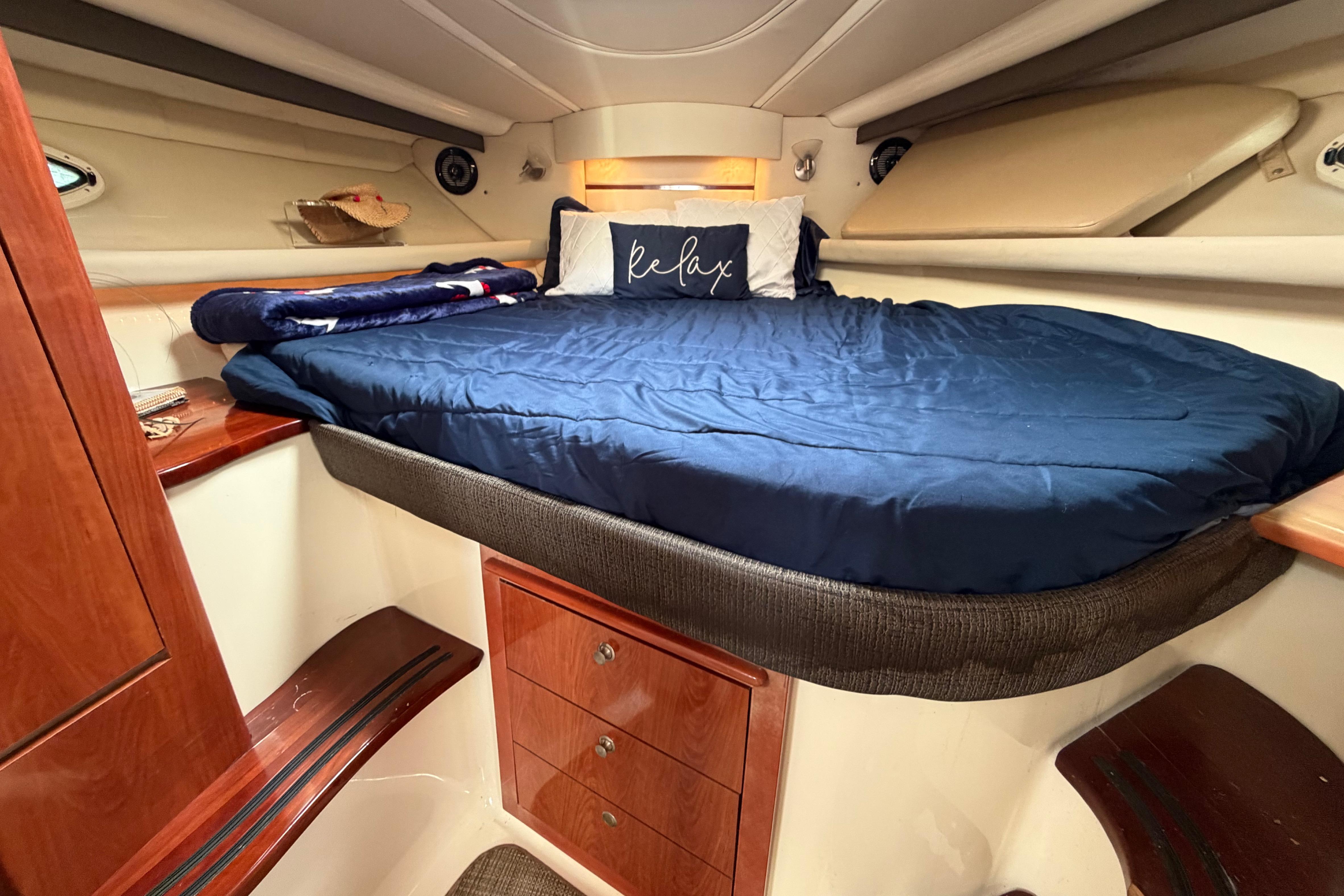 Luxurious cabin interior of 2007 Monterey 350 Sport Yacht with cozy bedding and wooden accents.