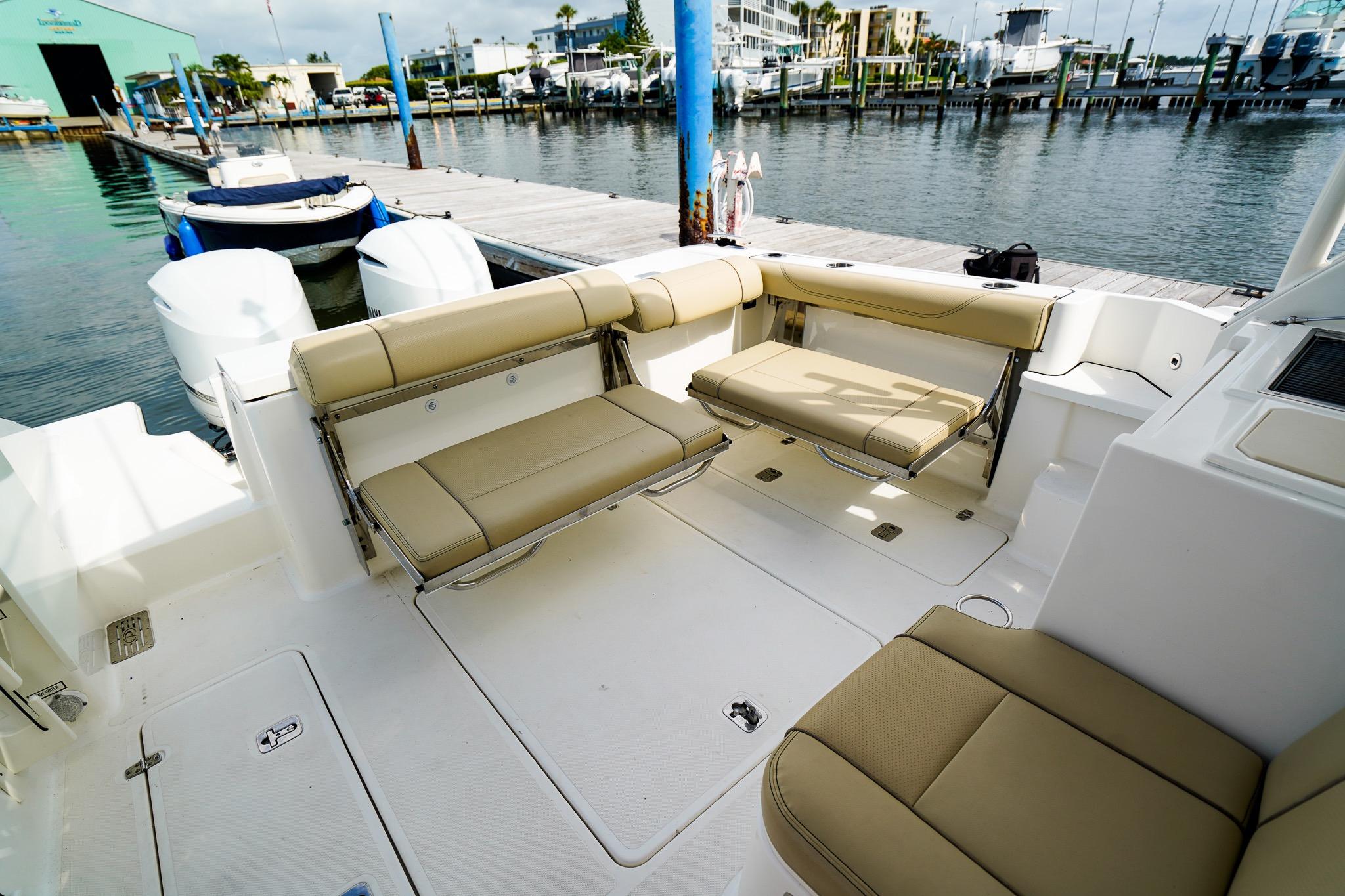 2020 Pursuit OS 325 Offshore boat interior with beige seating at marina.