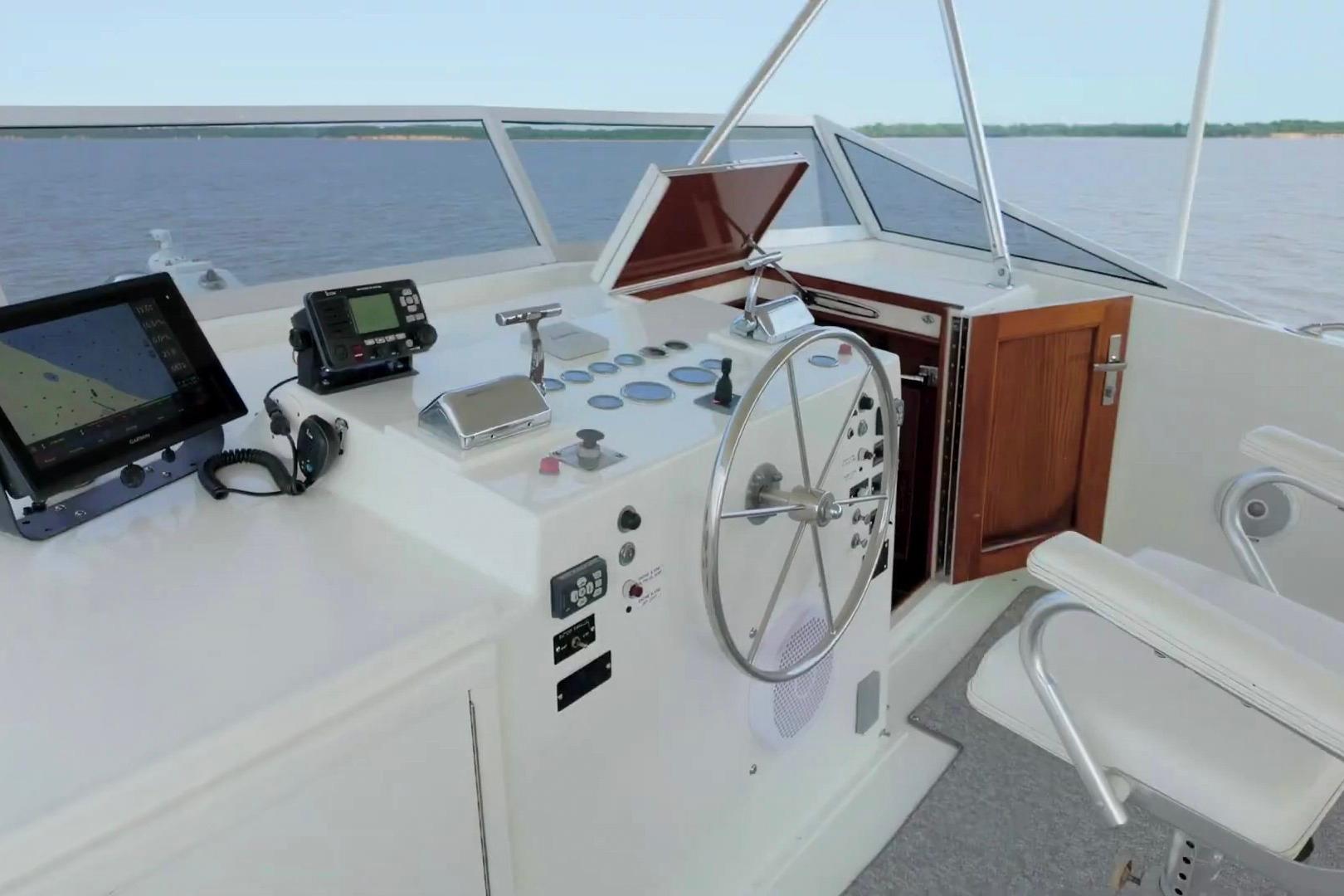 Helm of 1980 Hatteras 70 Motor Yacht with navigation equipment and steering wheel.